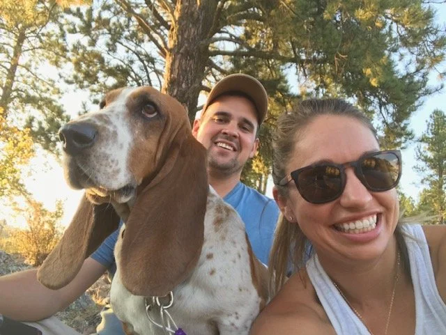 Reuben, owner of Ascent Window Tint + Clearbra in Fort Collins, Colorado, poses with his wife, Lindsey, and their basset hound, Berkeley.