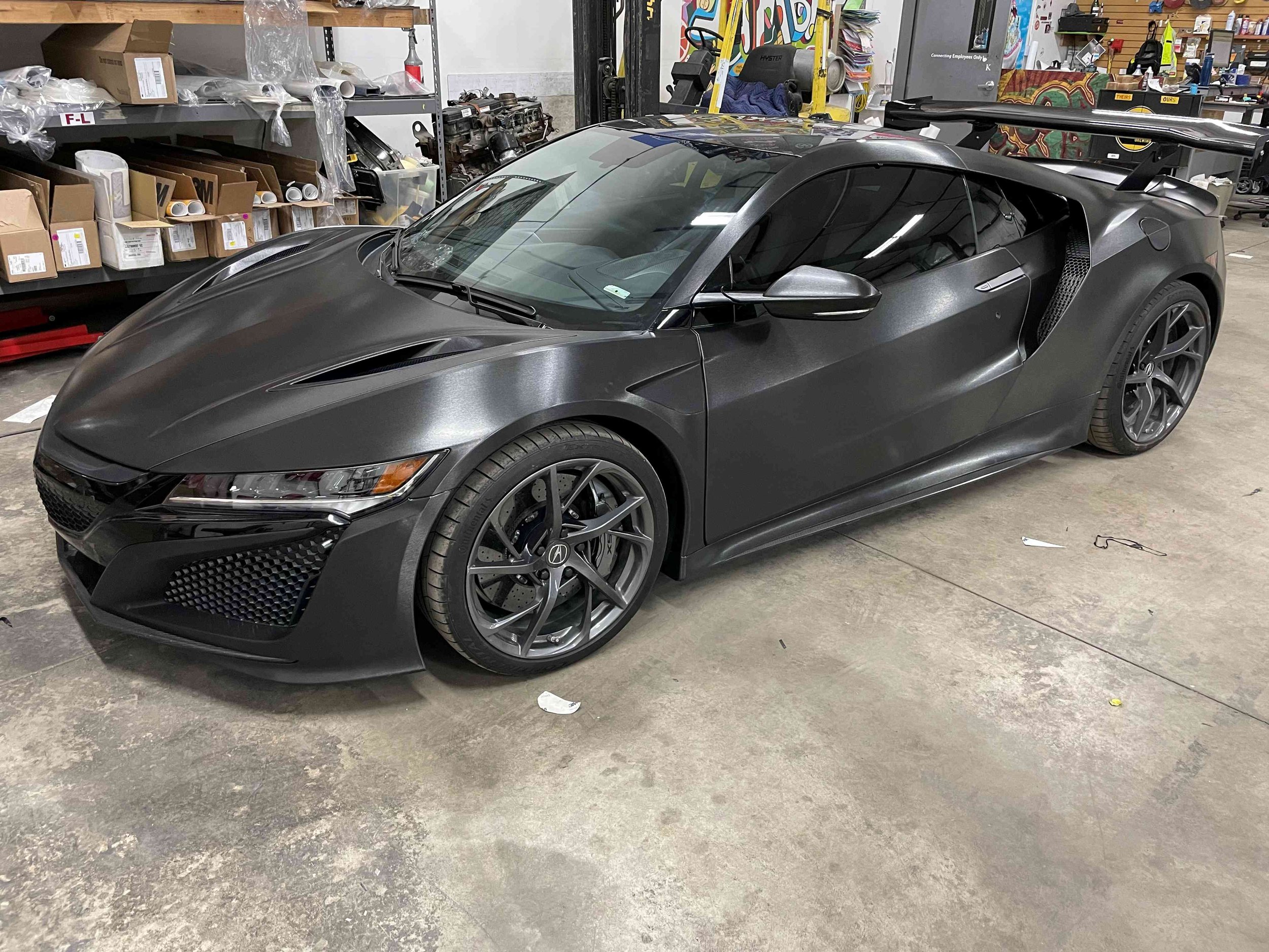 Acura NSX luxury sports car with a large rear spoiler parked in Ascent Window Tint + Clearbra shop in Fort Collins, Colorado after a full wrap and window tint. NOCO