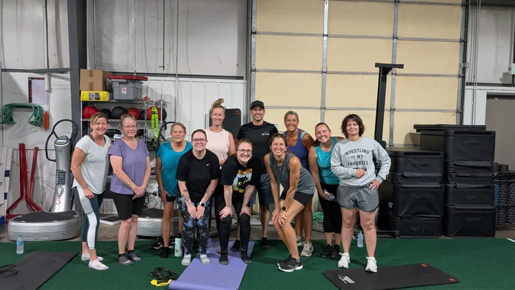 Sam Moses with a group of moms after a workout in the gym