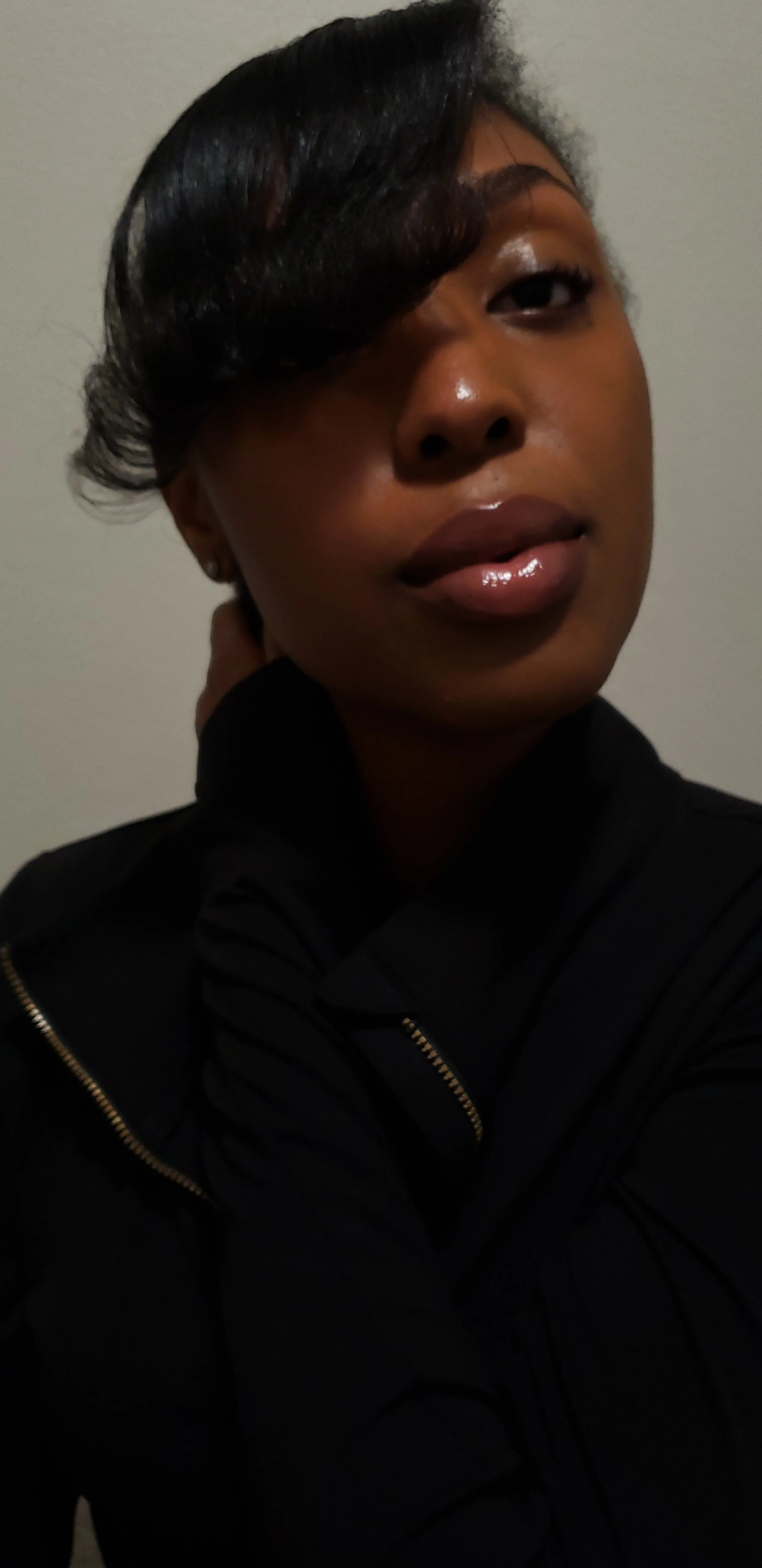 Person with short dark hair wearing a black jacket