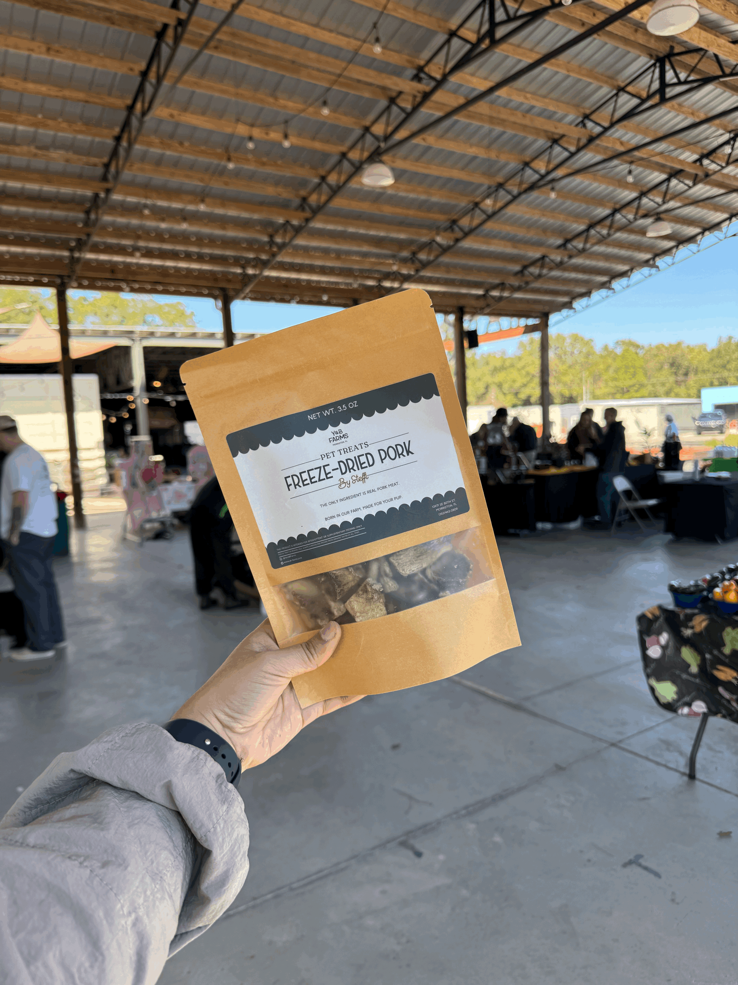 Bag of Y&B Farms freeze-dried pork liver pet treats held at a Florida farmers market.