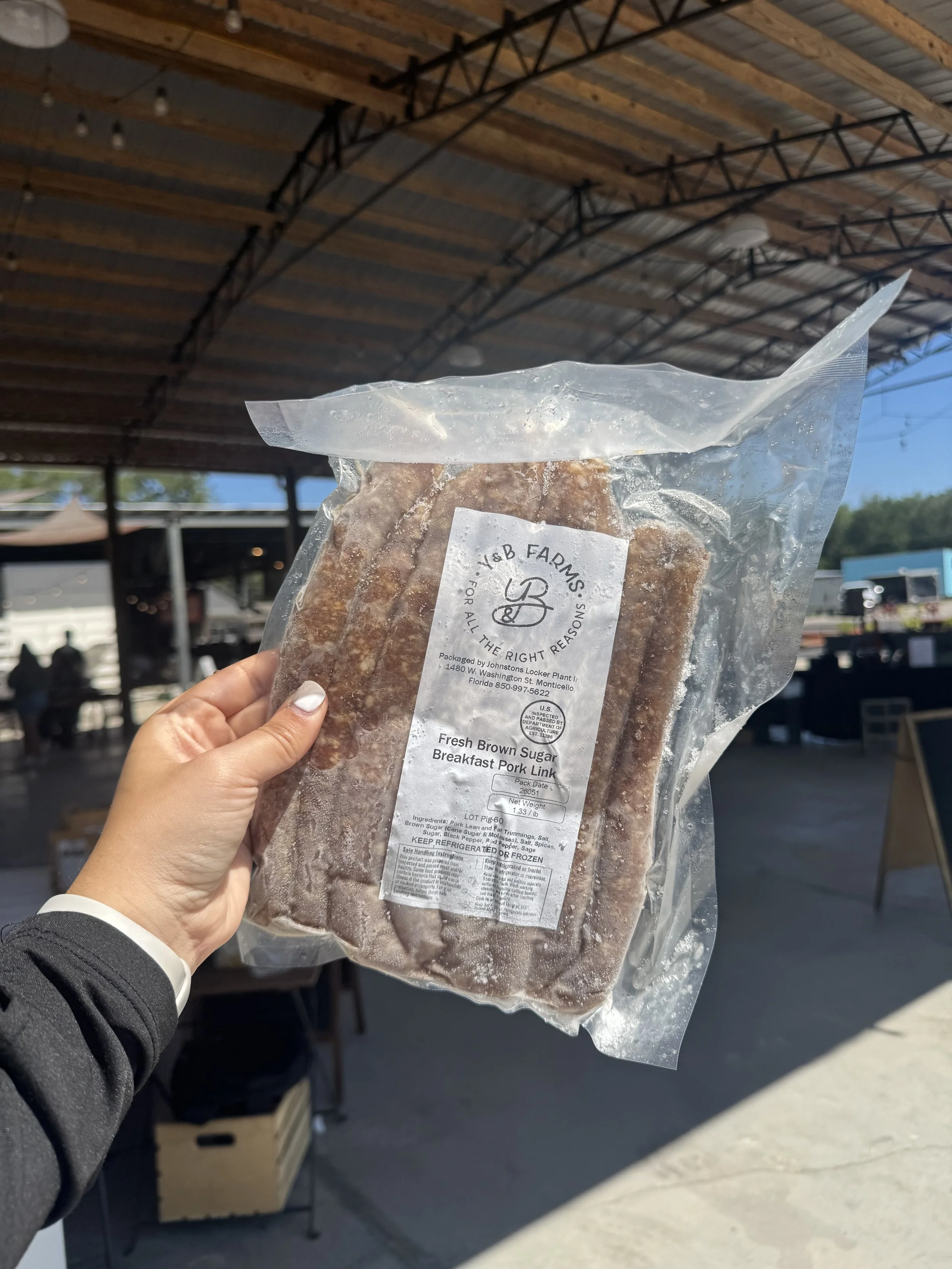 Hand holding Pasture Raised Fresh Brown Sugar Breakfast Pork Links from Y&B Farms