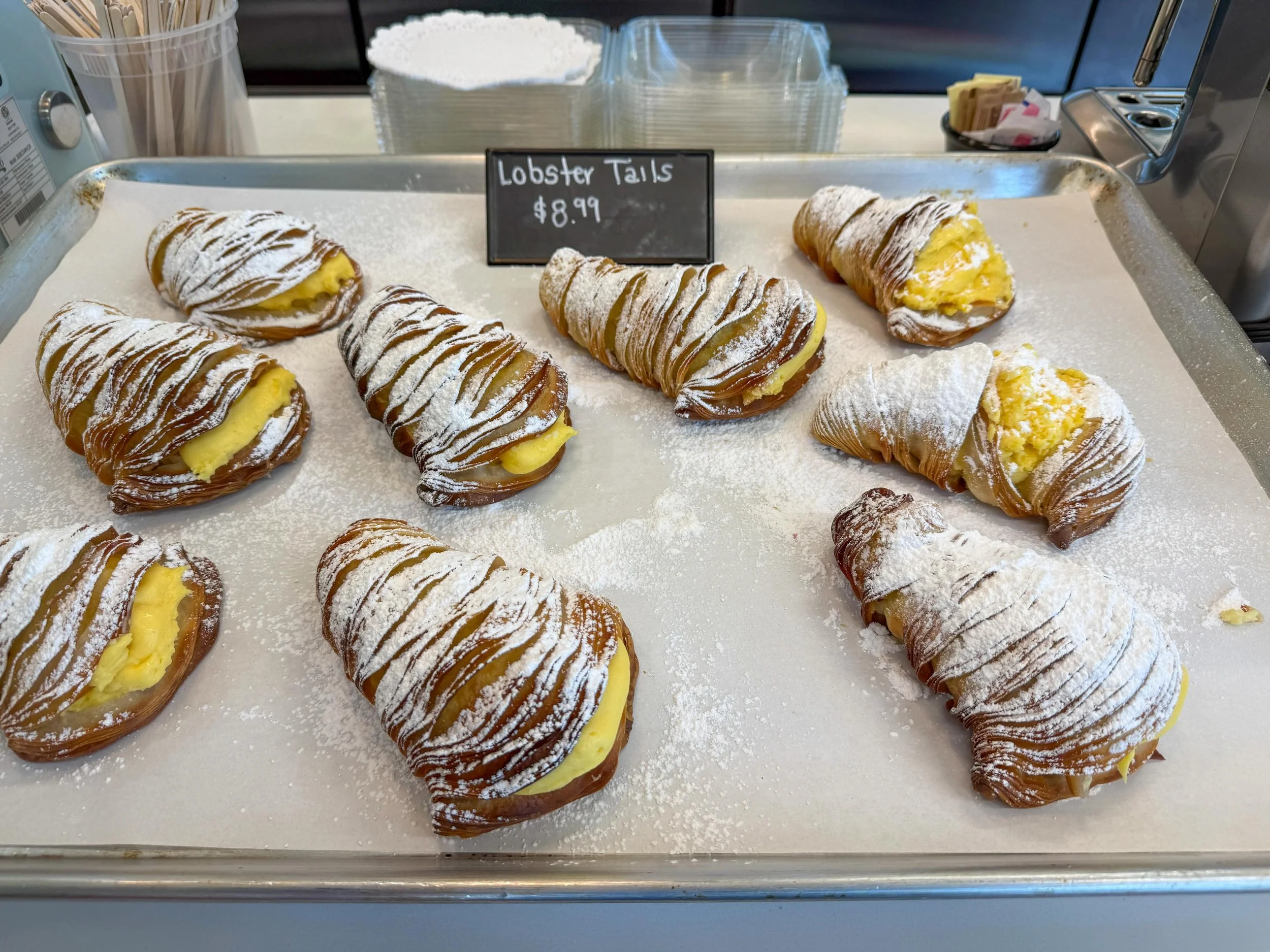 There is a very specific sound a lobster tail makes when you bite into it. 

Hundreds of paper-thin pastry ribbons, each one snapping in sequence, around a cool ribbon of golden cream. A snowfall of powdered sugar on top, half of which ends up on you