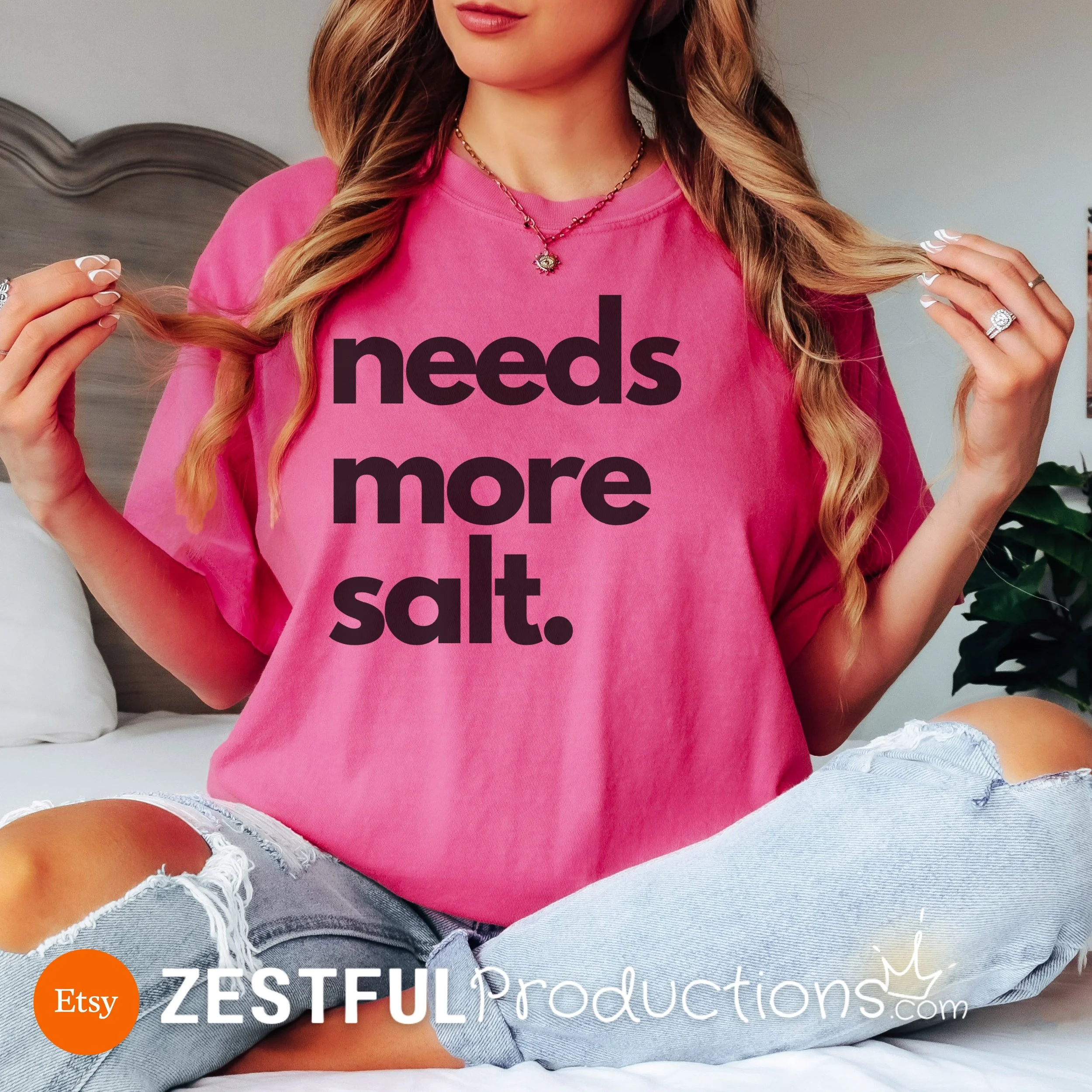 Bright watermelon pink ‘Needs More Salt’ t-shirt styled with ripped jeans – funny chef gift for her or him.
