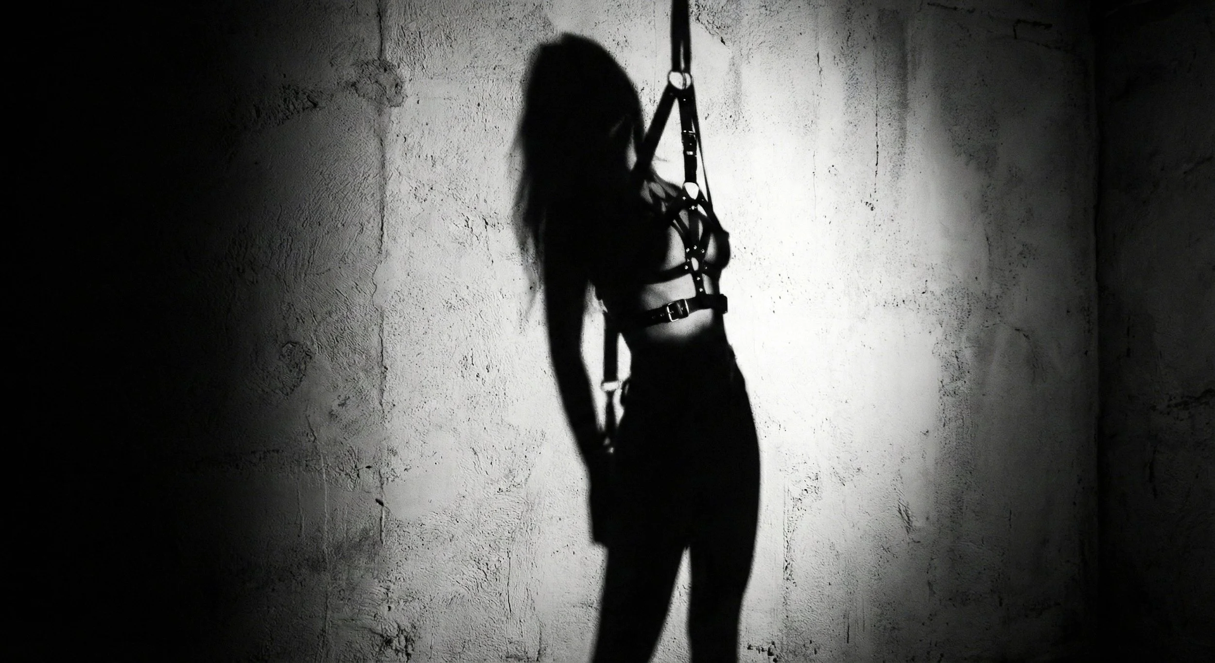 woman with bondage belt shadow photography b&w