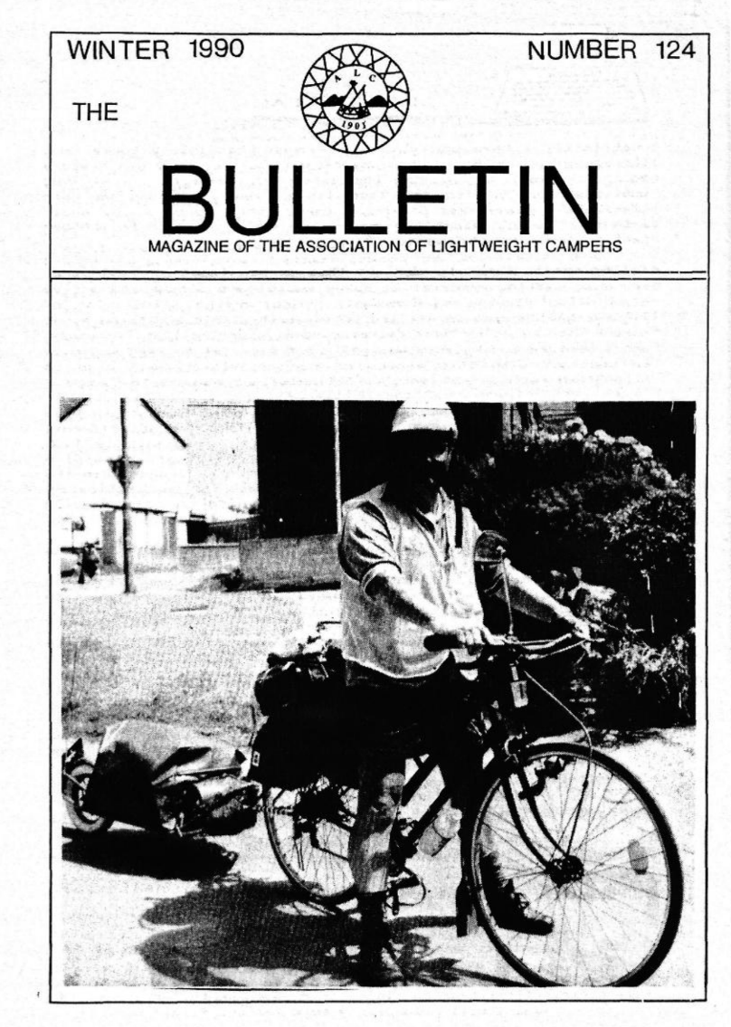 A vintage magazine cover titled 'The Bulletin,' Winter 1990 issue, featuring a photograph of Rik Appletree with his loaded bicycle and trailer being towed behind it.