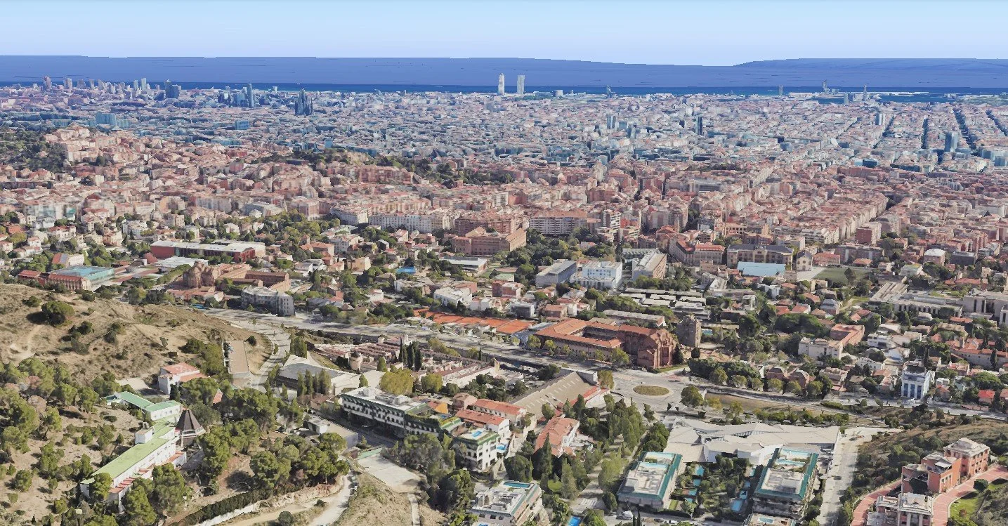 Vista panorámica de una ciudad con edificios y calles, vistas hacia el mar en el horizonte, en zonas montañosas.