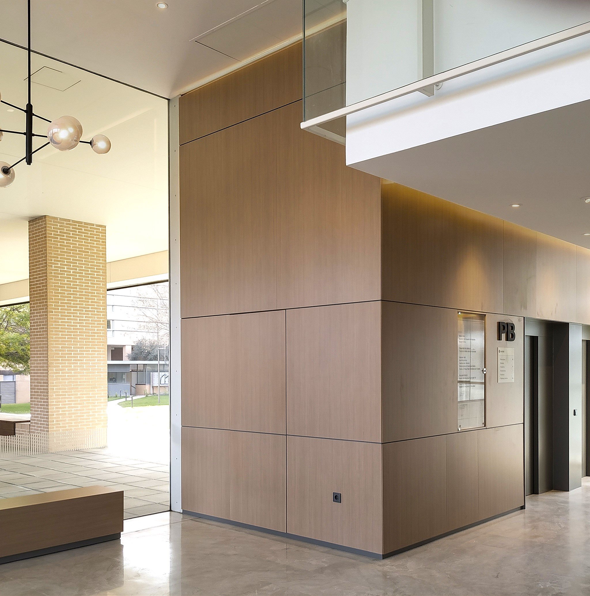 Interior moderno con paredes de madera y un techo con luces empotradas, visible también una lámpara de detalles esféricos.