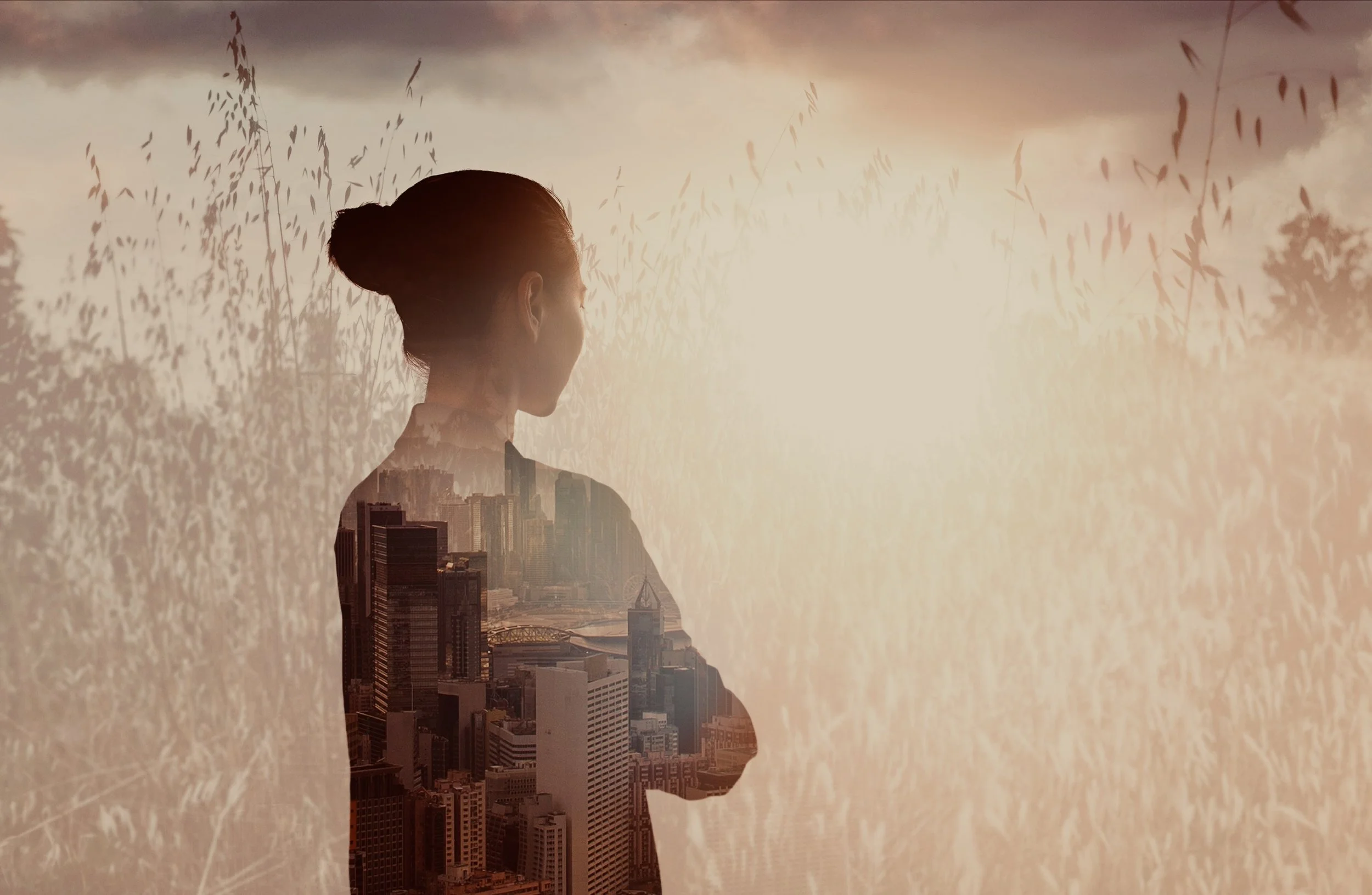 Silhouetted figure of aperson in profile with an urban cityscape layered withn the body against a textured, lightfilled background. The image reflects seeing relationshups across inner awareness and external structures, emphasizing connected perceive
