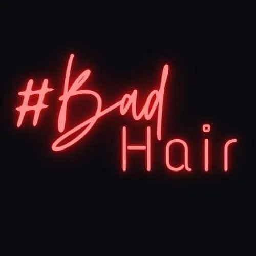 Neon sign displaying the words '#Bad Hair' in red lettering on a black background.