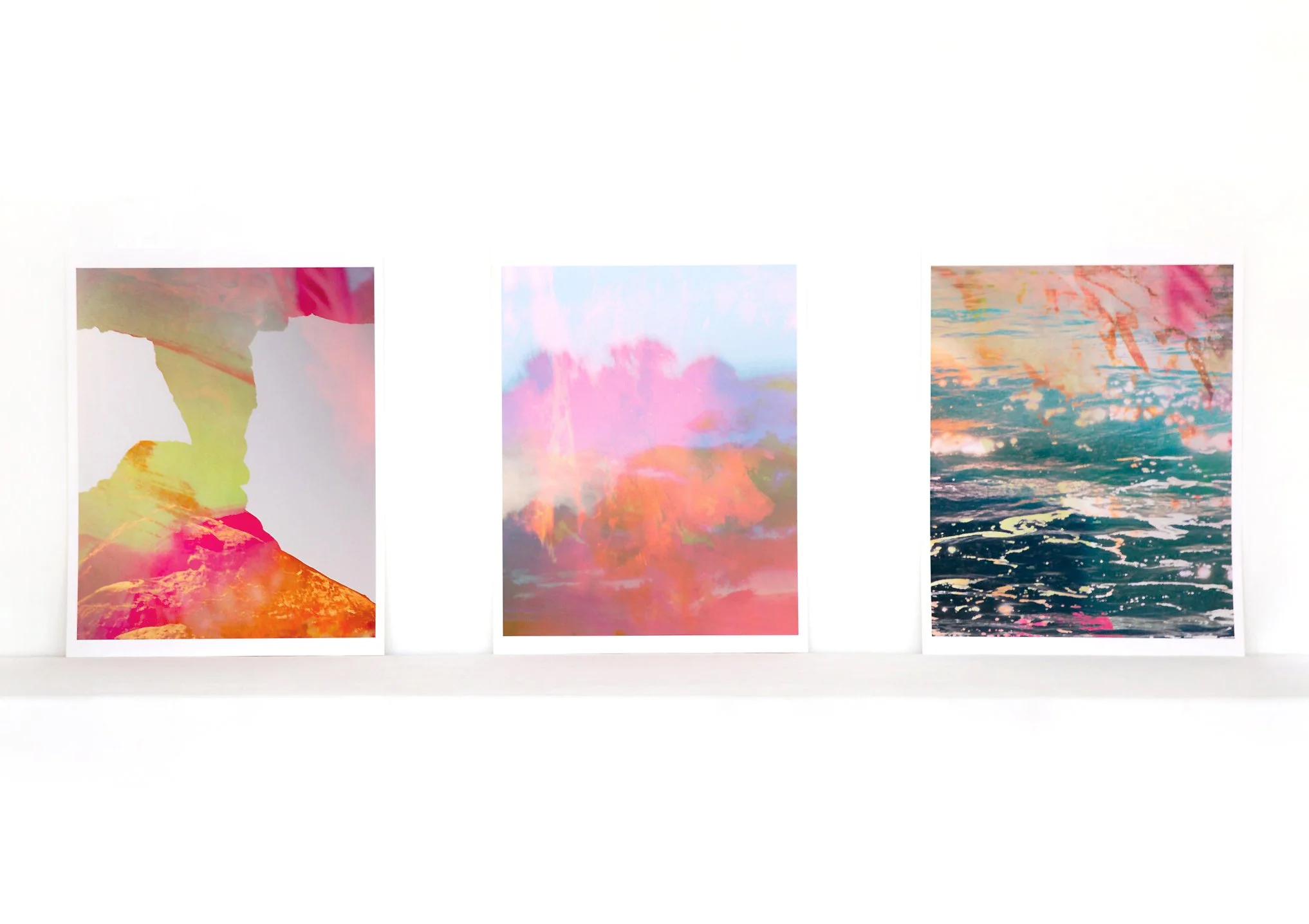 Three limited-edition fine art prints from Faith-Ann Young’s Elemental Meditations series displayed on a white ledge — Stone, Air, and Water — abstract, luminous works inspired by grounding, breath, and flow.