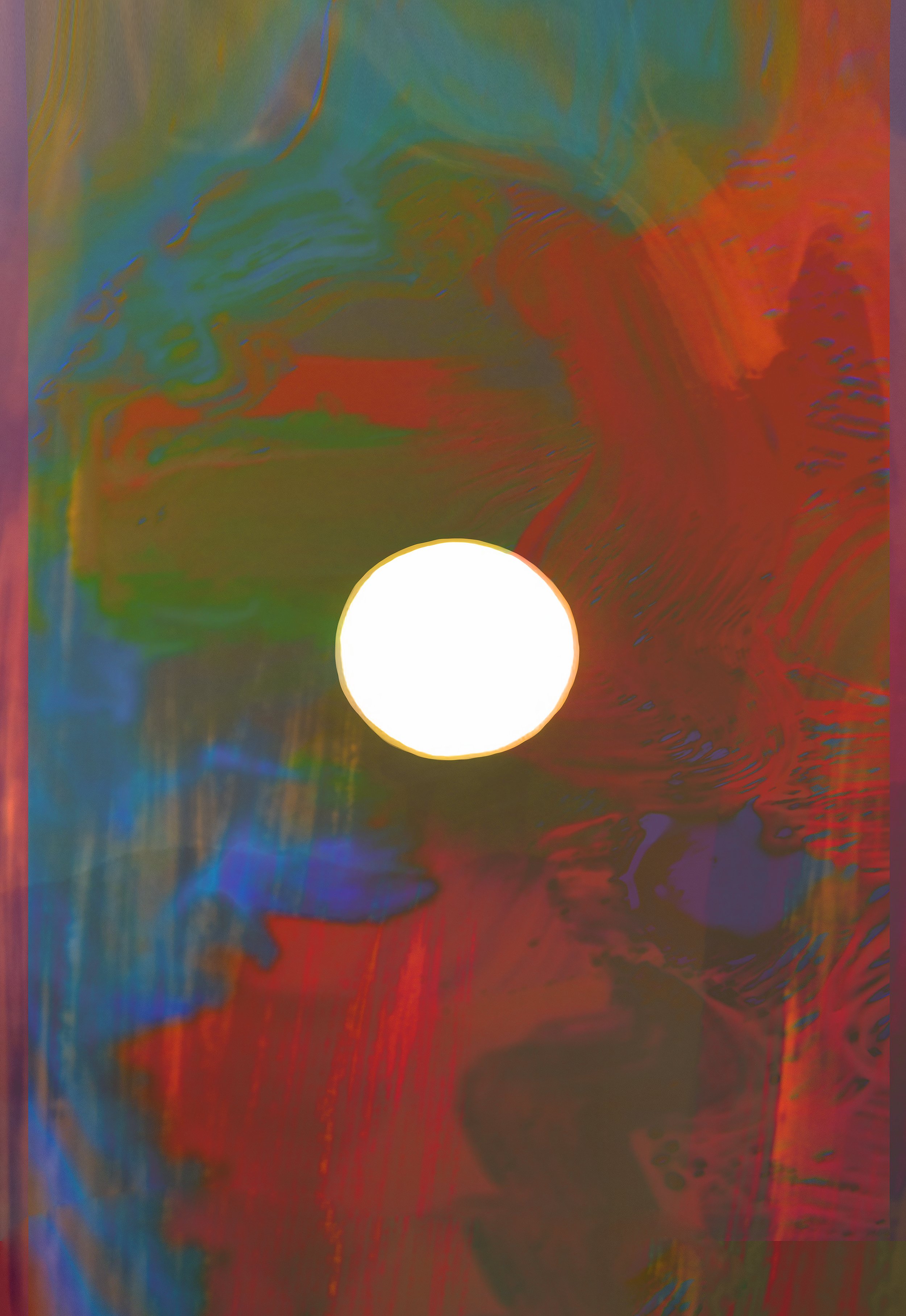 Abstract colorful swirling pattern with a bright white circle in the center.