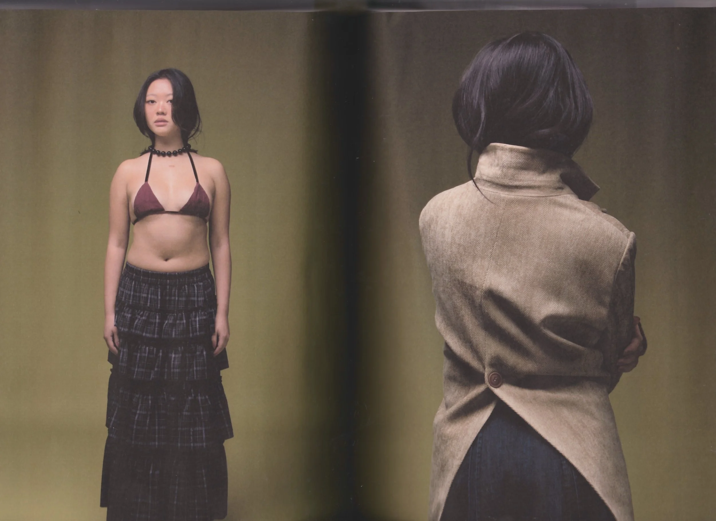 A woman with short black hair in a distressed pose, facing away, wearing a beige coat and dark pants. In another frame, a woman with shoulder-length black hair standing facing forward, wearing a halter top, a beaded necklace, and layered plaid skirts.