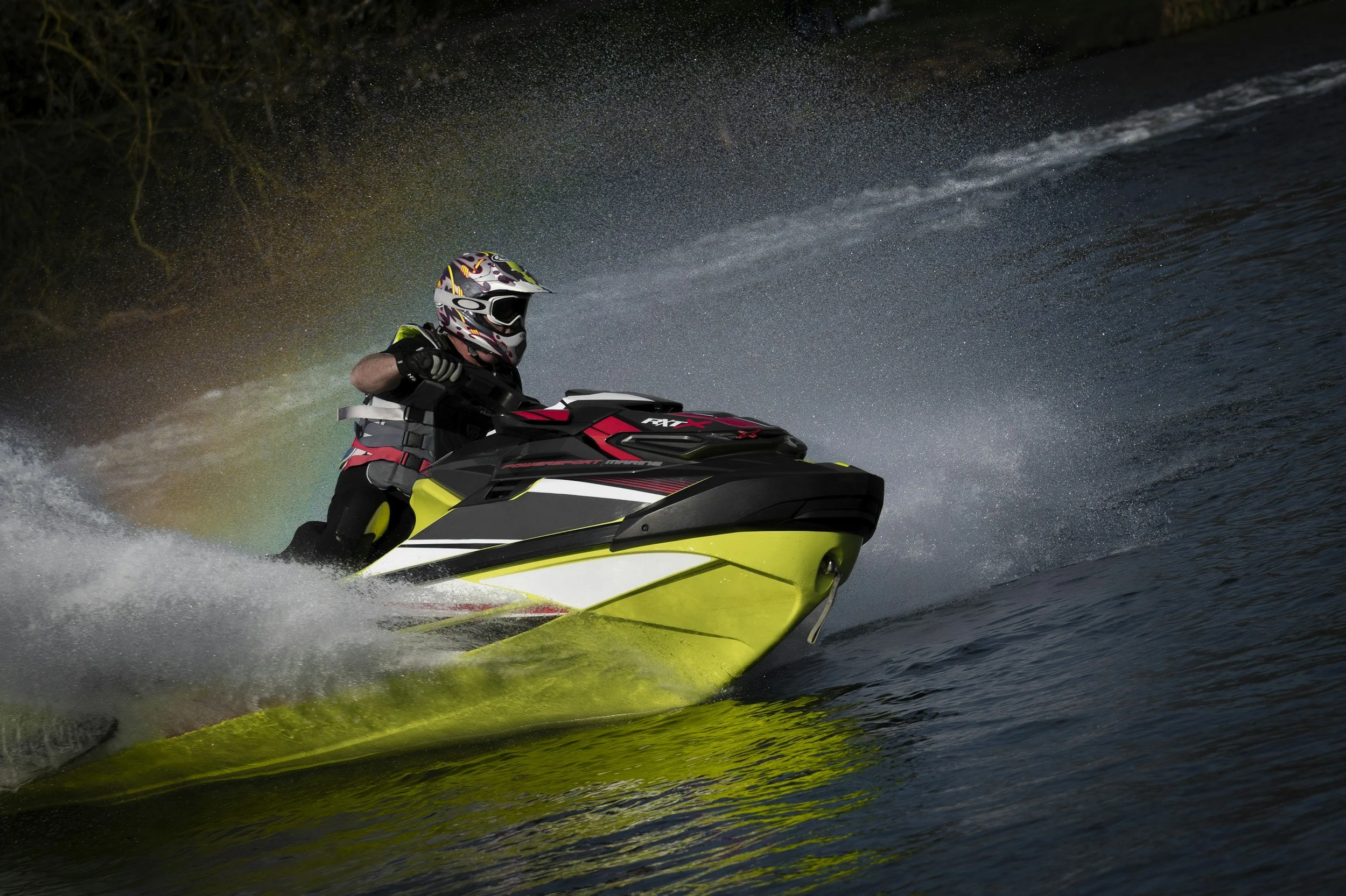 Person riding a yellow and black jet ski waverunner yamaha kawasaki  on water at night with a starry sky and trees in the background.