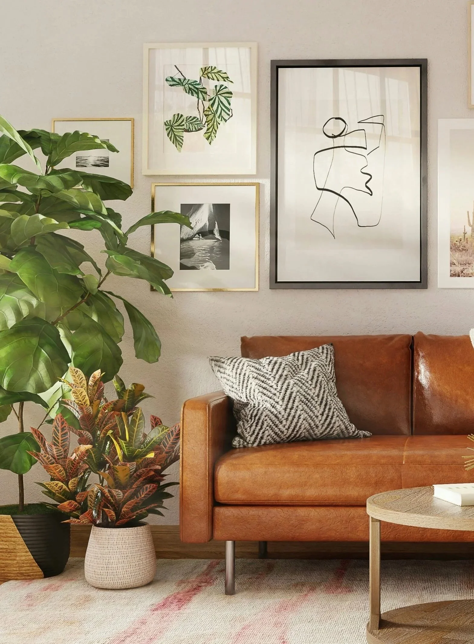 A cozy living room corner with a brown leather sofa, a black-and-white patterned pillow, and a small round side table. There are large green houseplants, including one with red and green leaves, in woven baskets. A collection of framed botanical and art prints hang on the wall, including a sketch of a face and a leaf illustration. The floor has a light-colored rug with subtle pink accents.