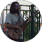 A person holding a guitar in a room with a window and some furniture.
