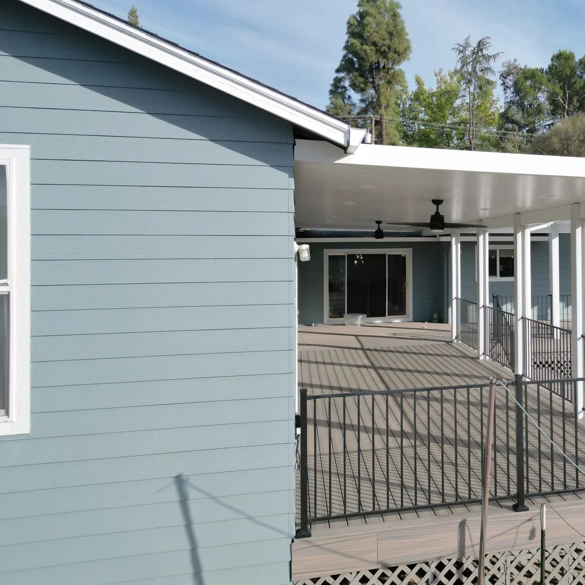 Central Builders was hired as the general contractor for this Sacramento home, featuring blue vinyl siding, black metal railings, and trex composite decking.