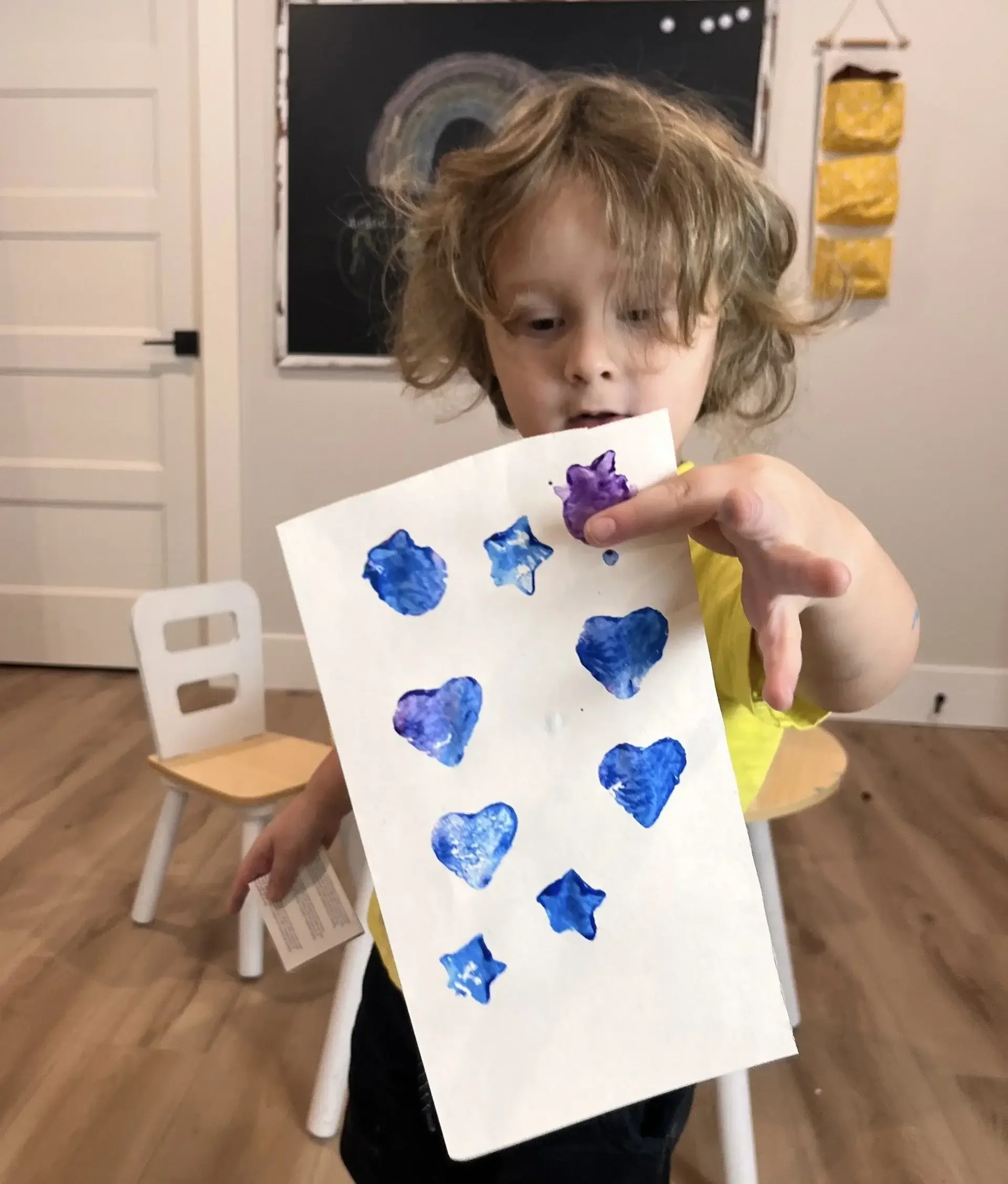 Child proudly showing completed ABA task to reinforce positive behaviour and learning.