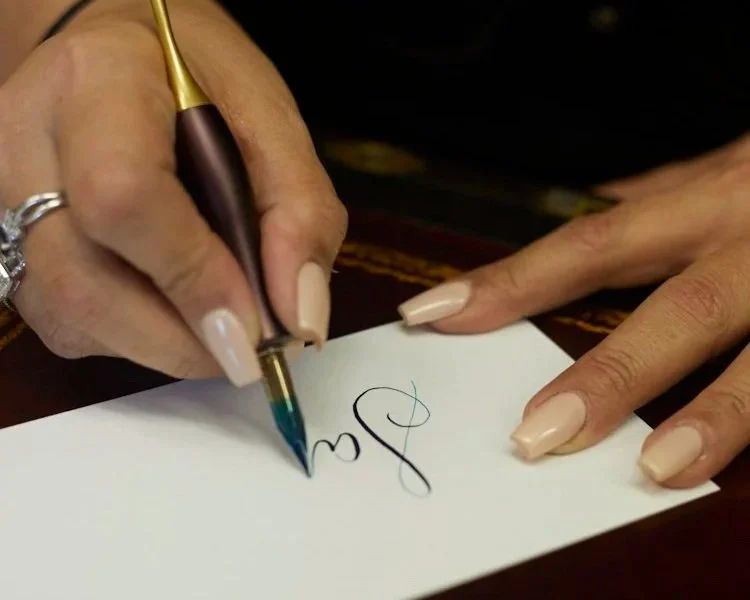 Cambridge Calligrapher starting to hand letter a name