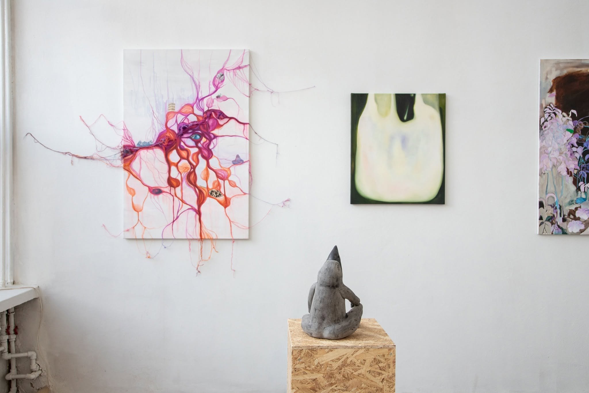 Wide gallery shot of contemporary ceramic sculpture on a pedestal displayed in the the exhibition SPACETIME  UN[B]LOCKED, featuring human-like bird.