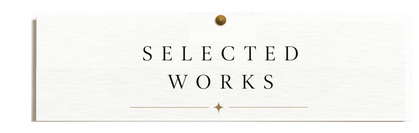 A white sign with the text "Selected Works" in black, decorated with a gold star and gold lines, pinned to a wall with a gold pushpin.