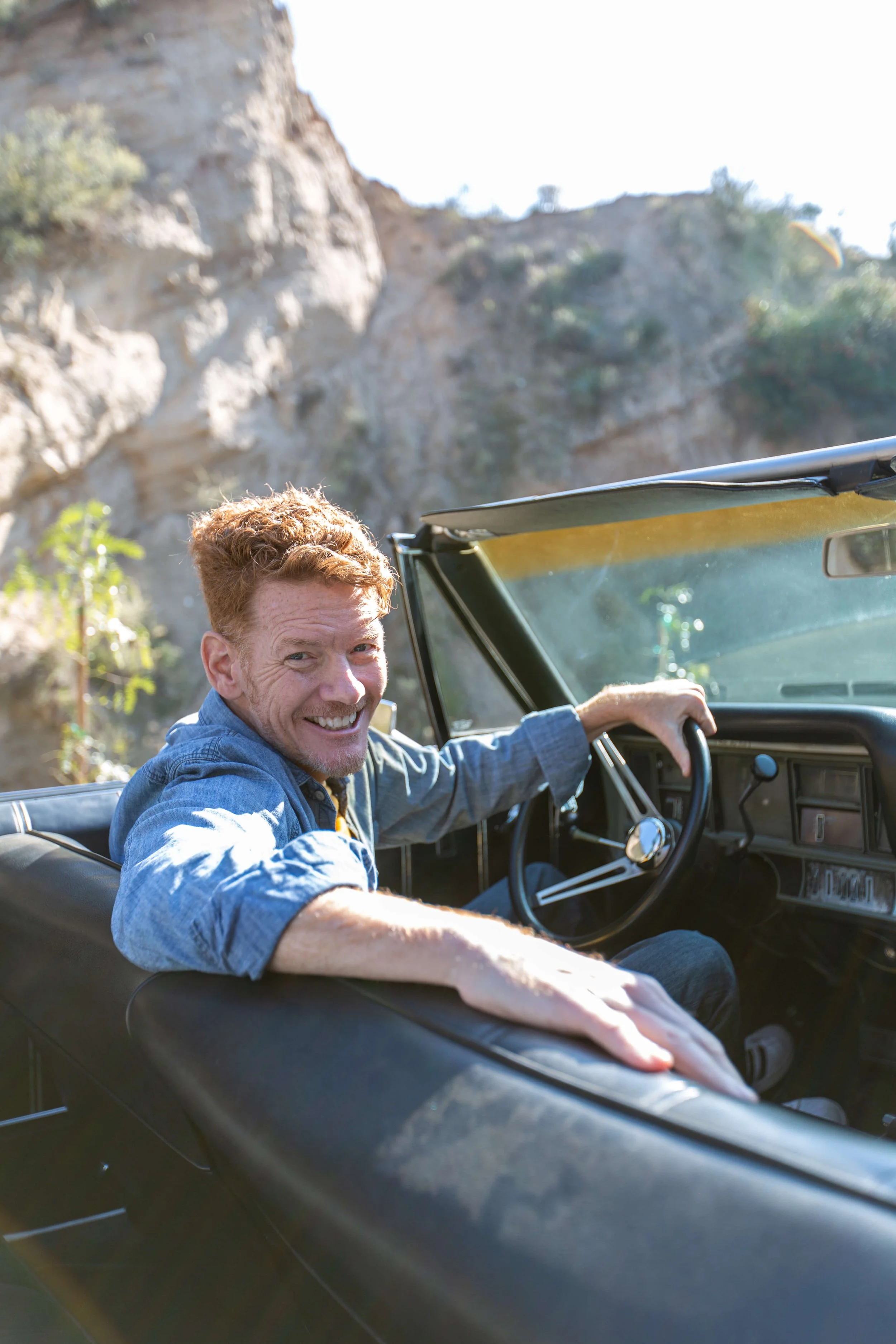 work_lifestyle-man-soaking-up-scenic-drive-in-classic-convertible-car-2.jpg