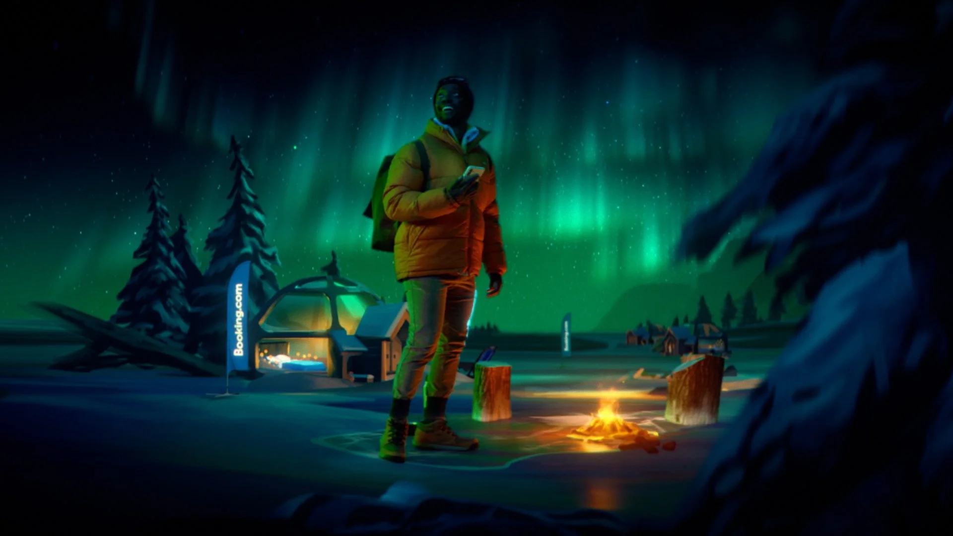 A person standing outdoors at night near a campfire in a snow-covered landscape with northern lights. There's a building with a sign that reads "Booking.com" and trees around.
