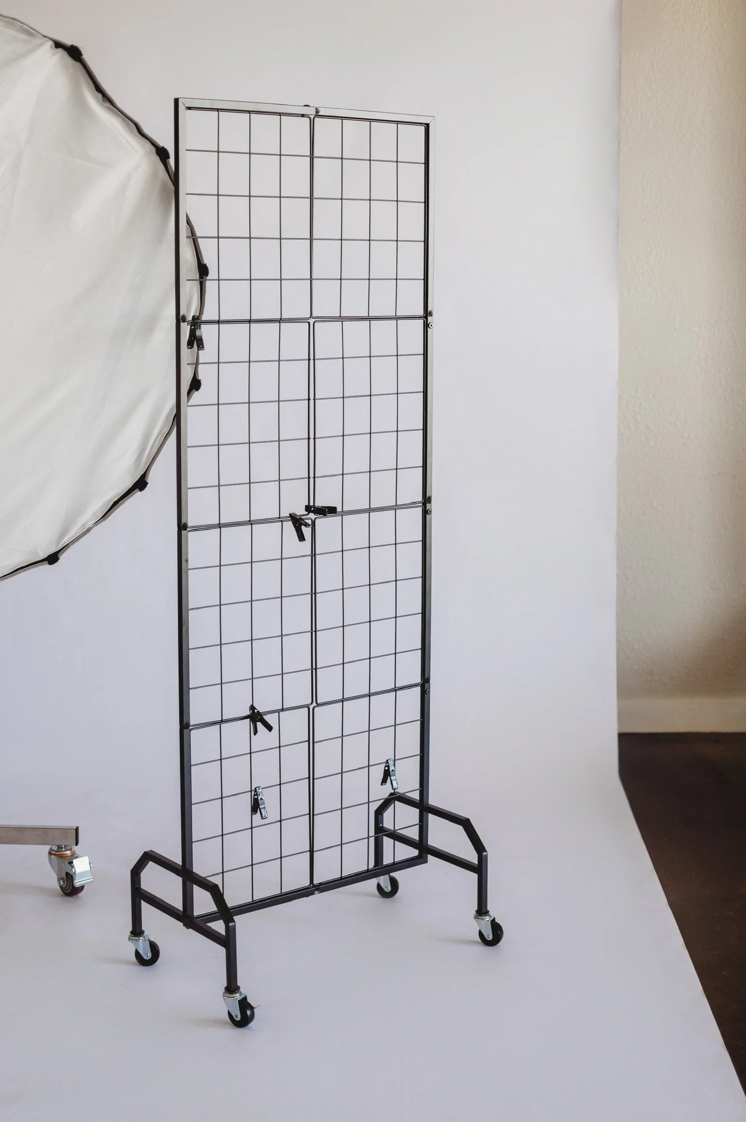 Industrial metal grid room divider and white photography reflector available at our women-owned content creator studio on the Gulf Coast.