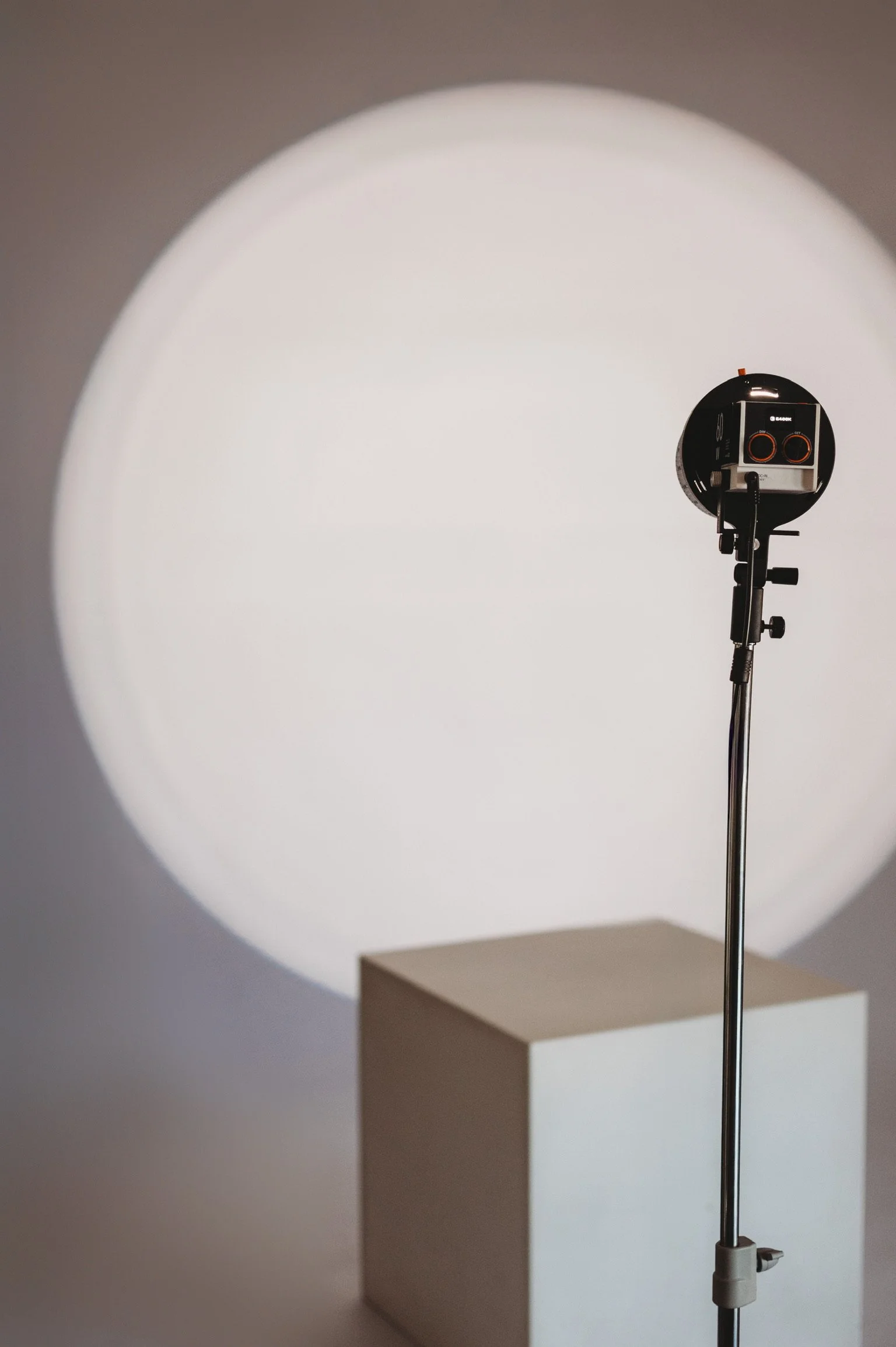 Studio strobe light with a white umbrella reflector set up on the hardwood floors of our creative studio space in D'Iberville Mississippi.