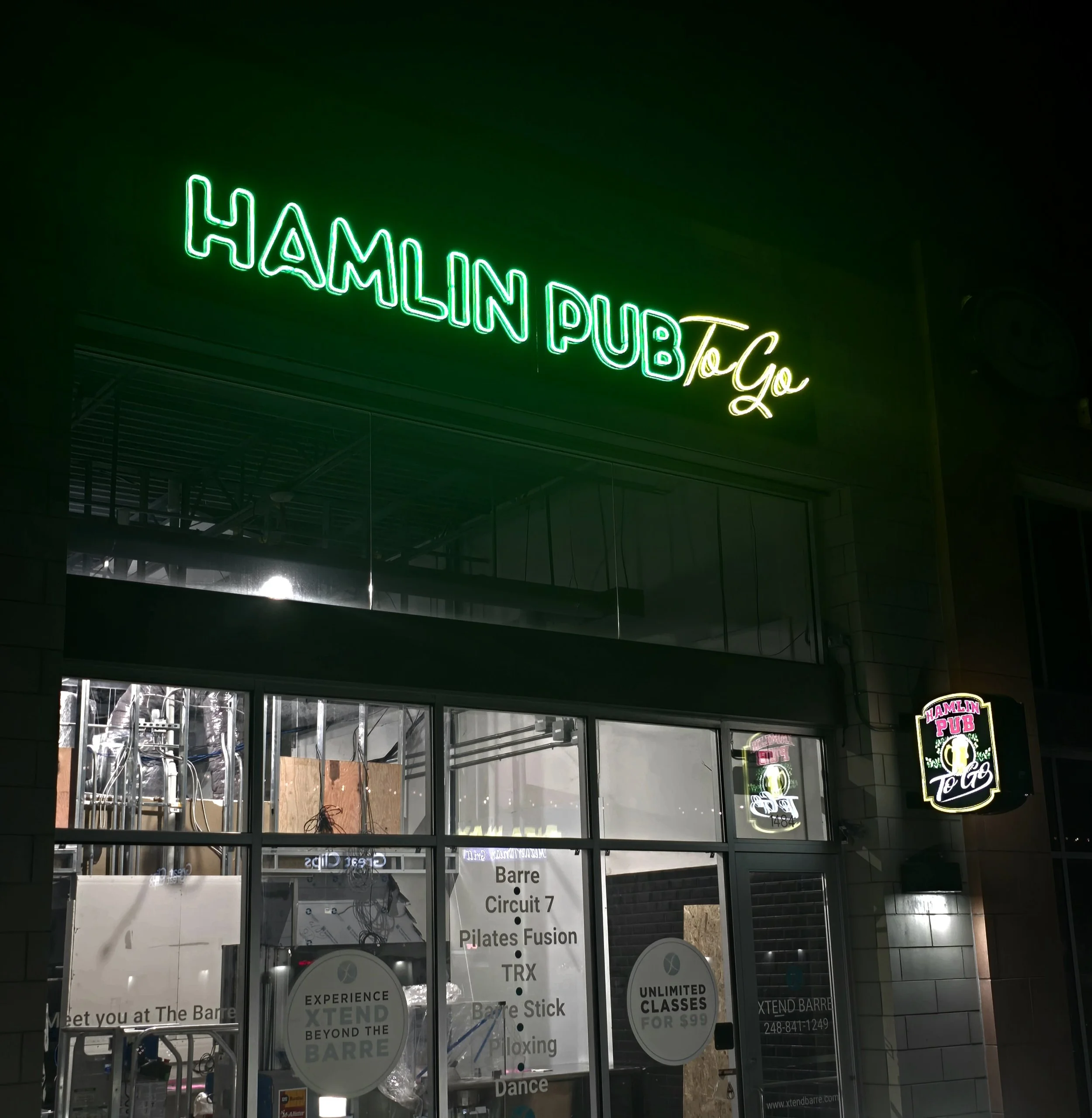 Custom neon sign reading 'Hamlin Pub To Go' above entrance to a bar.