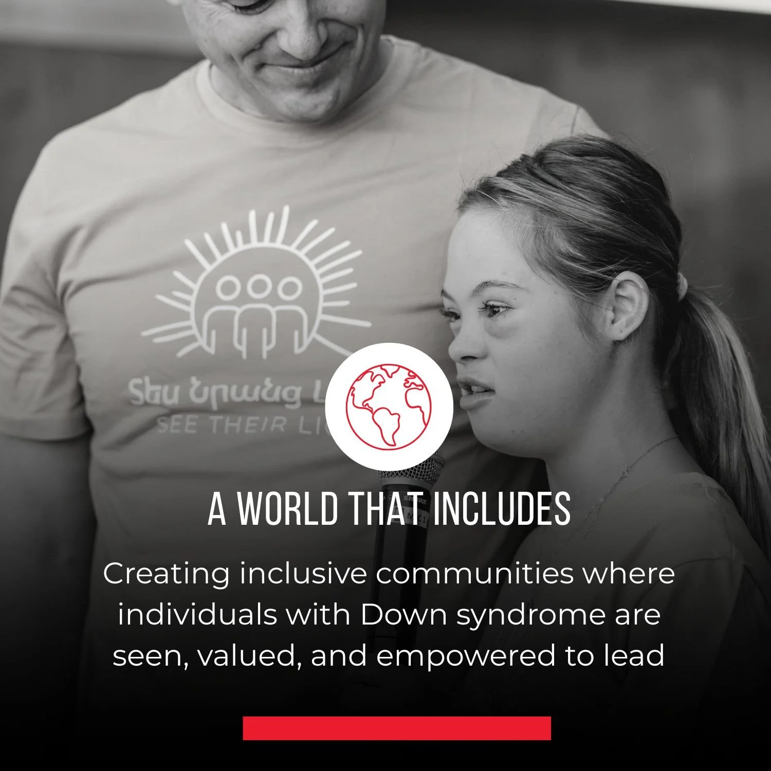 Black and white photo of a young girl speaking into a microphone, standing beside an adult man wearing a t-shirt with a logo and text about inclusion and seeing their lives; the logo features three human figures under a sunburst. The caption underneath reads, "Creating inclusive communities where individuals with Down syndrome are seen, valued, and empowered to lead."
