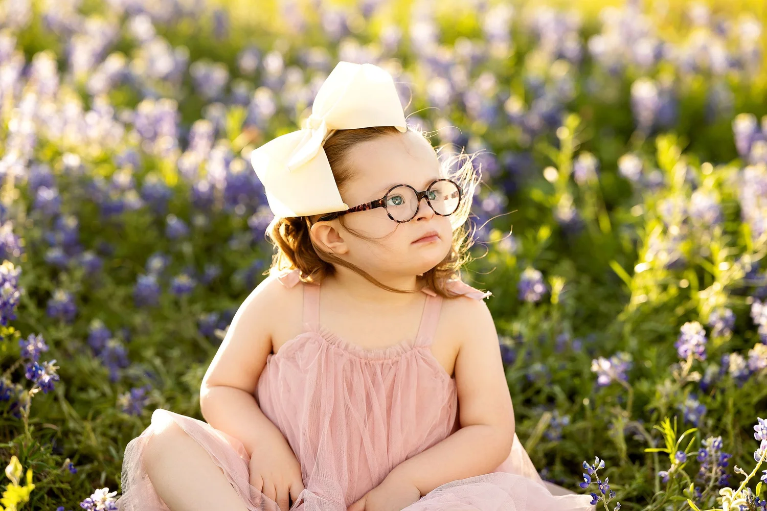 Lucy Claire standing among bluebonnet flowers