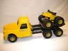 Yellow toy construction dump truck and yellow toy tractor with black wheels