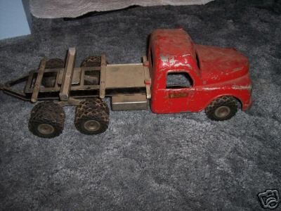Old red toy flatbed truck on gray carpet