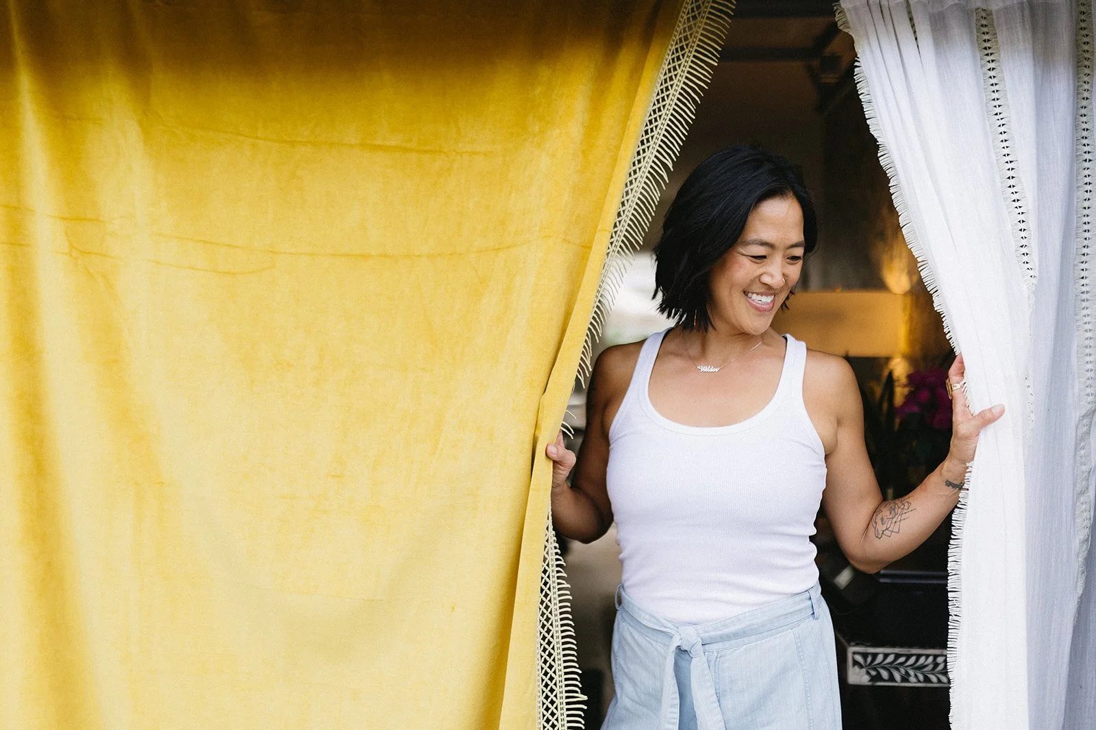 Judy Tsuei between gold and white curtain