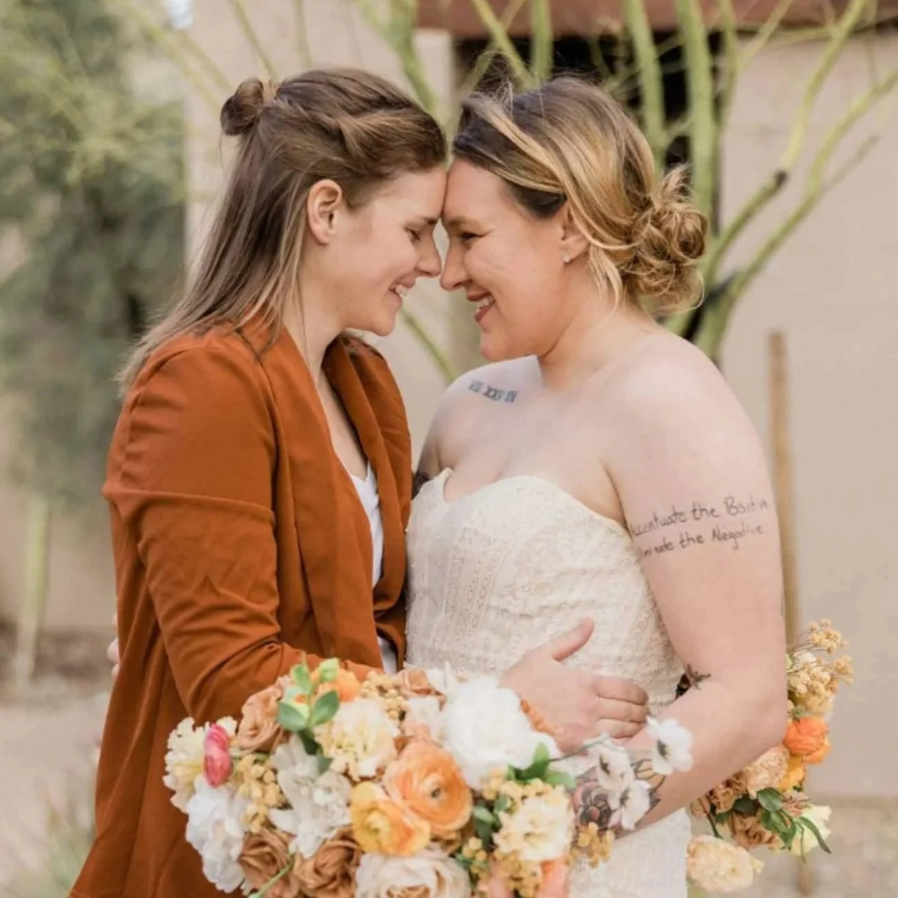 lesbian couple at their wedding, embracing each other outside