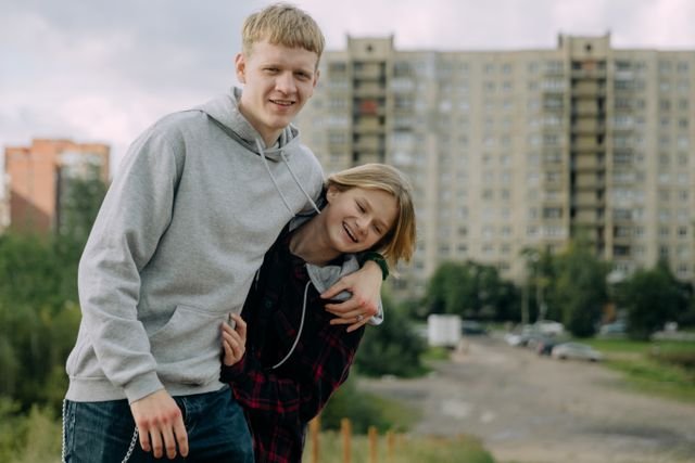 Two Teens side hugging outside