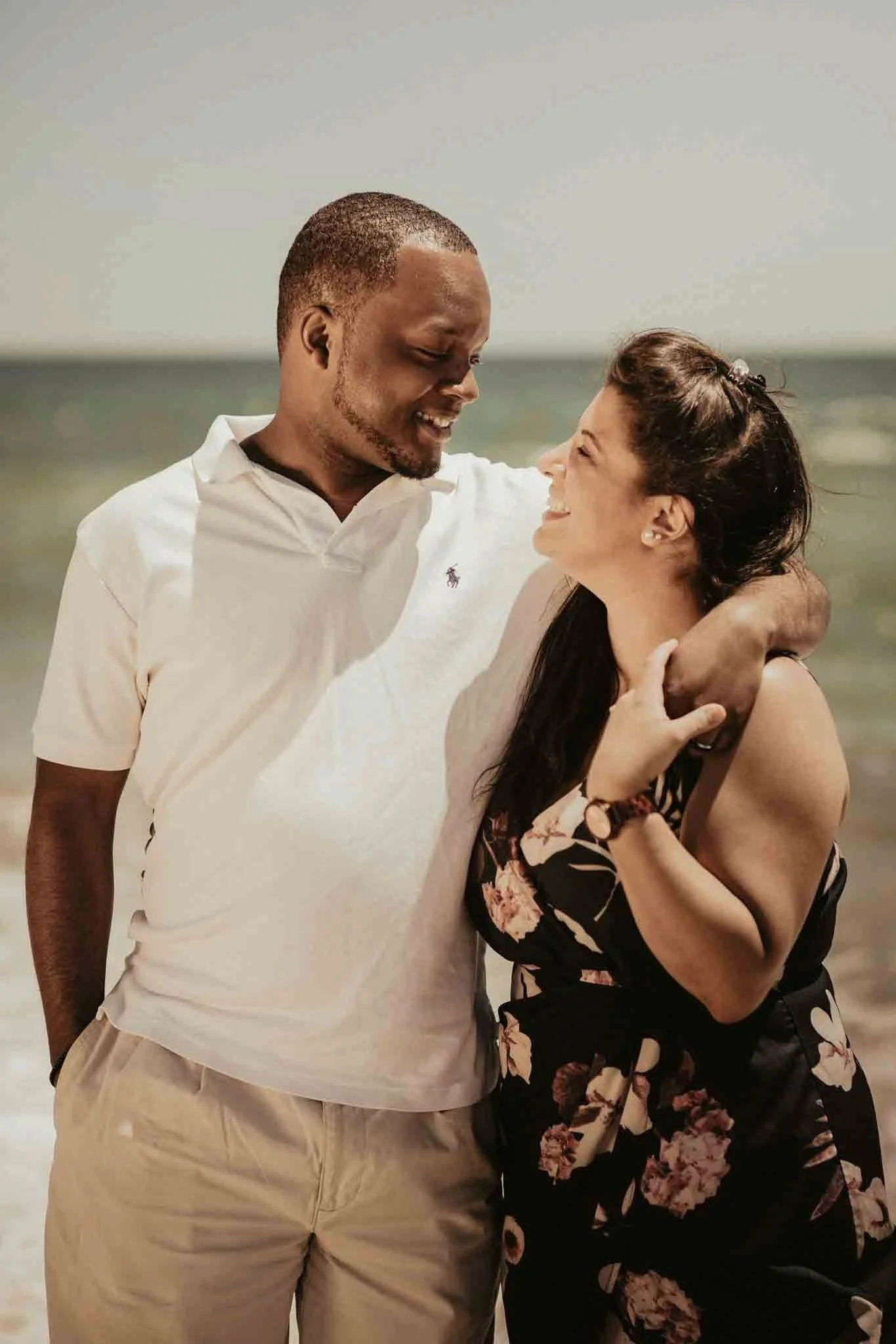 couple embracing on a beach setting looking at eachother