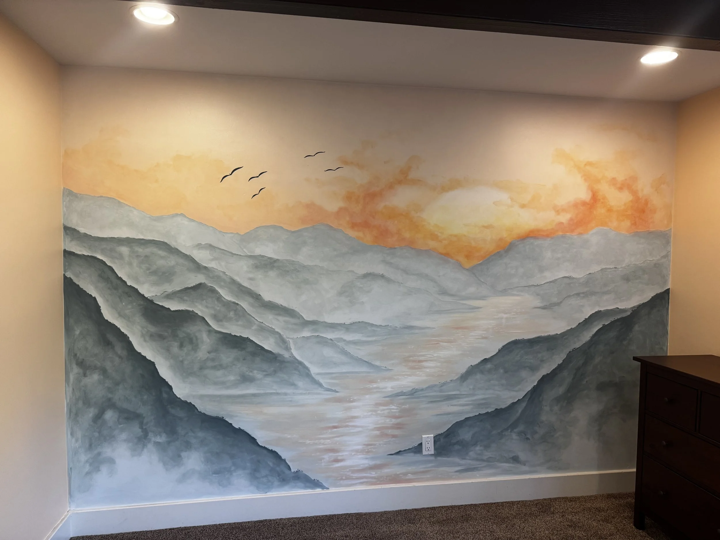 sunset over mountains and stream in watercolour on a nursery wall