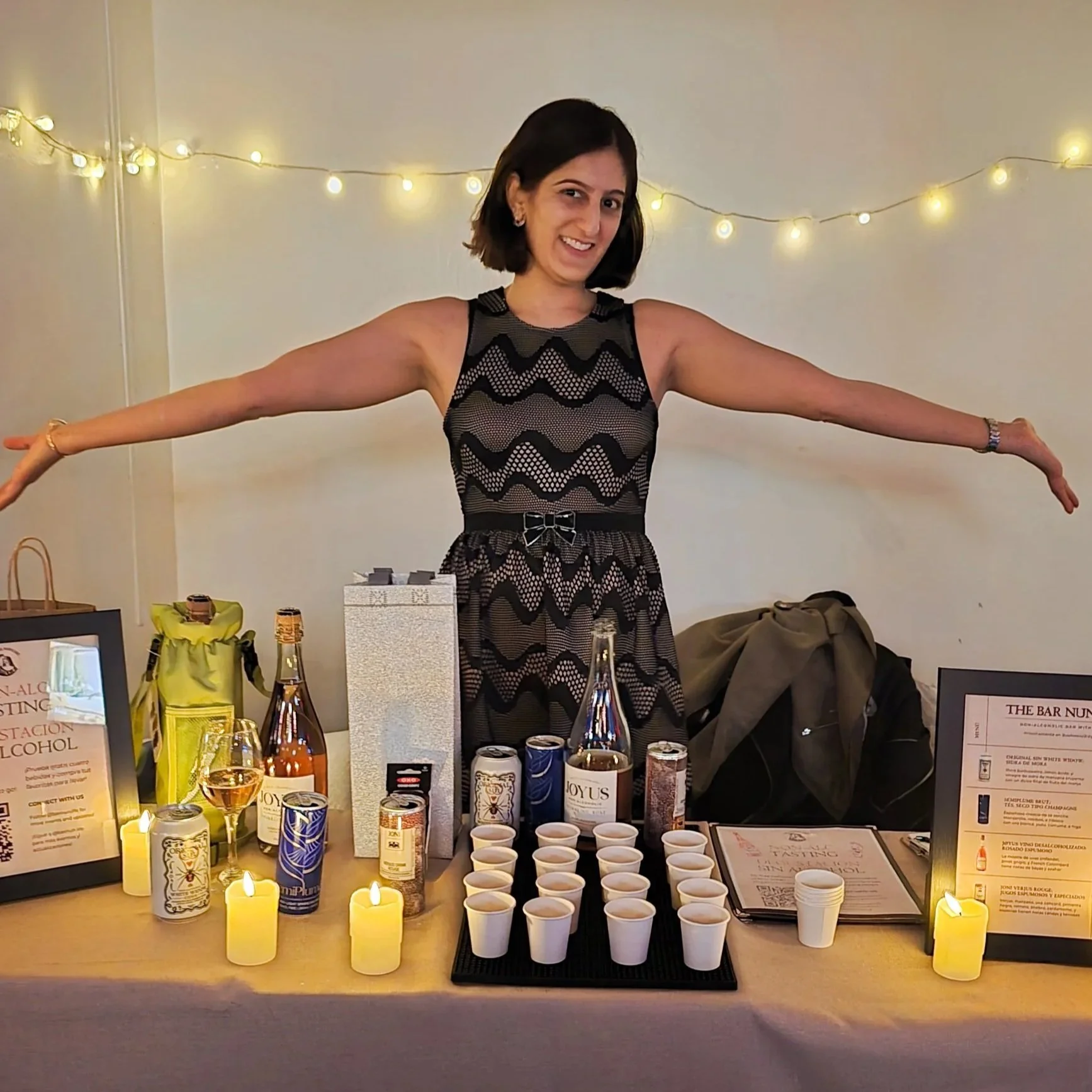 Bar Nun owner posing with drinks tasting table at Aby's Bar in Ridgewood, NY.