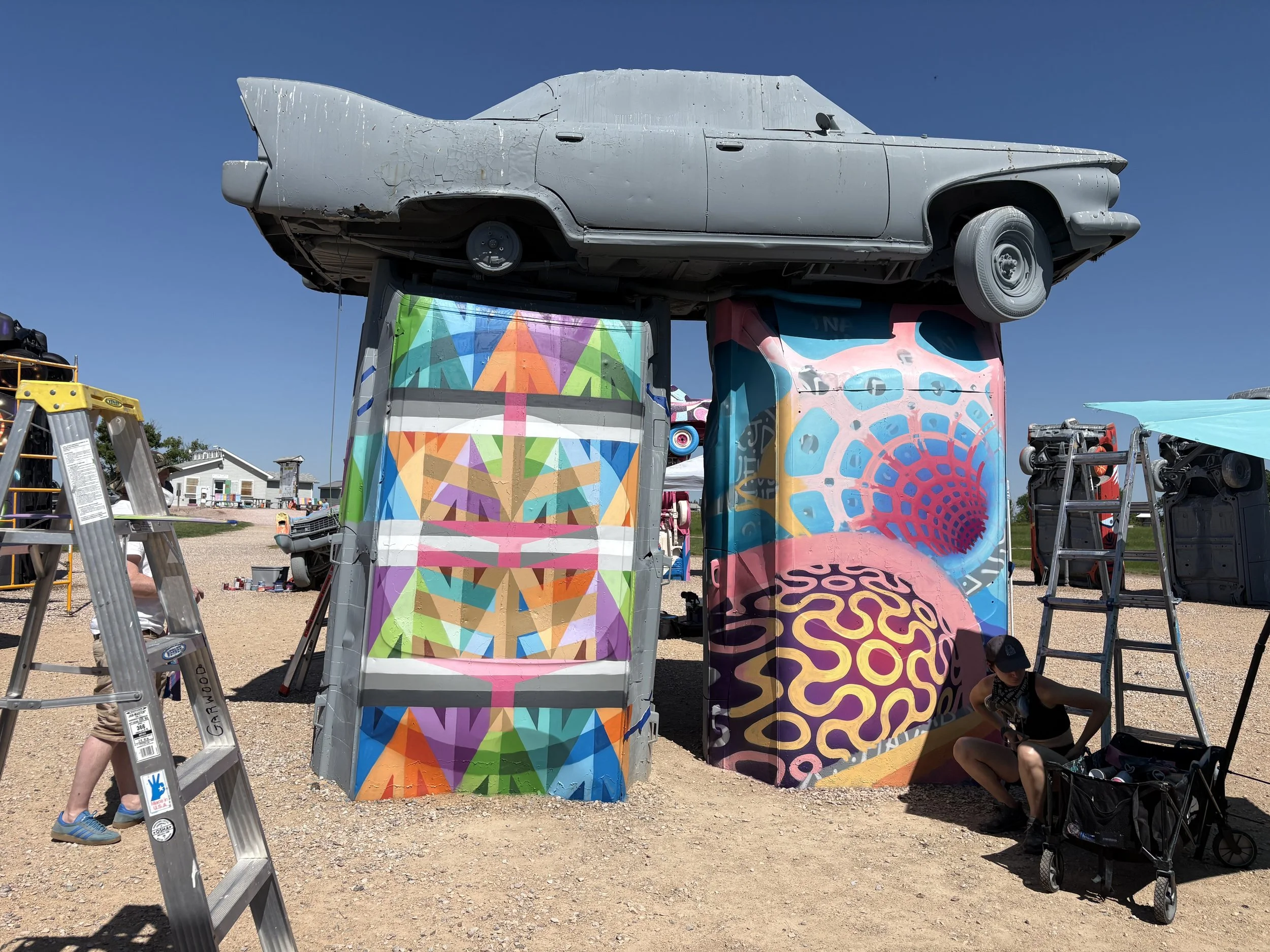 Muralist Anna Charney’s work in progress during the 2025 carhenge mural festival, street art