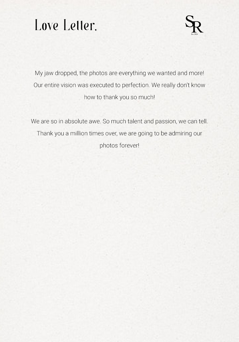 A modern wooden house with a lake and mountain range in the background during sunset or sunrise.