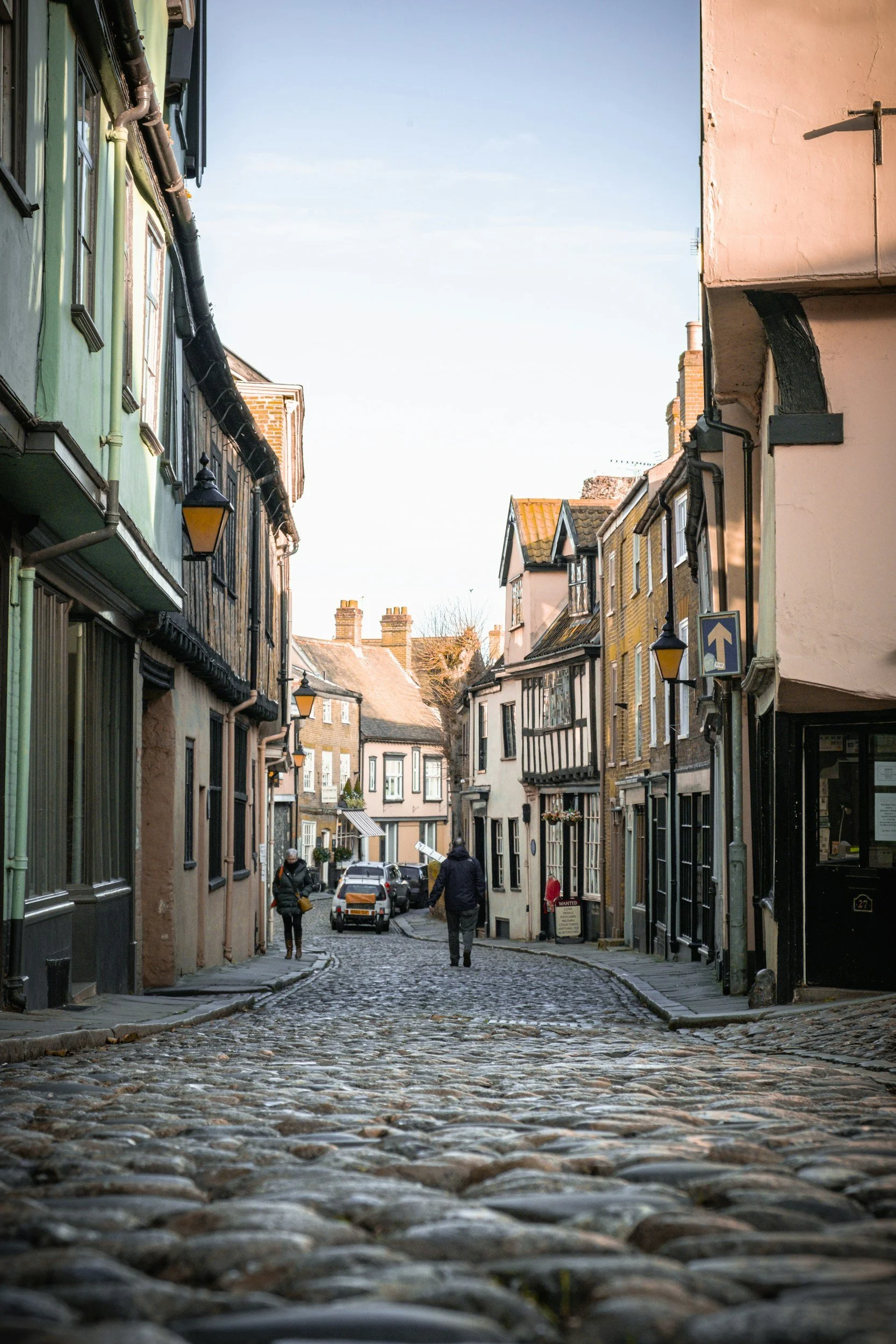 A still from a public sector video shoot in norwich. The image shows Norwich lanes in the daytime with people walking down the lane.