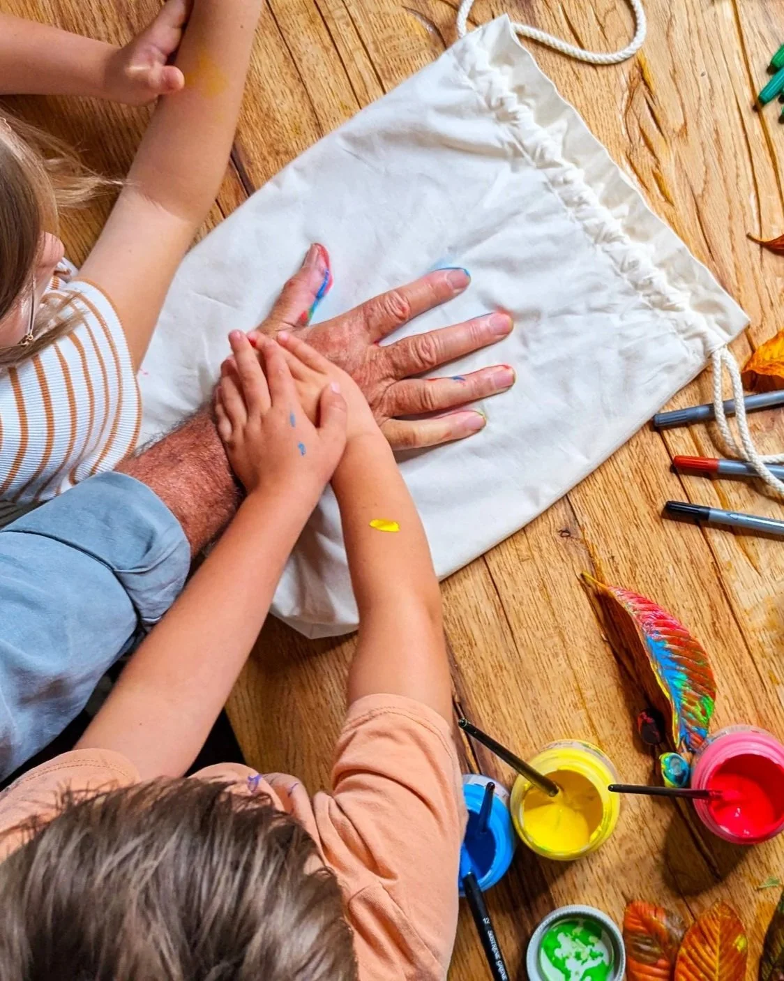 Kinder und Erwachsene bemalen gemeinsam den Aschebeutel einer Farvel Urne