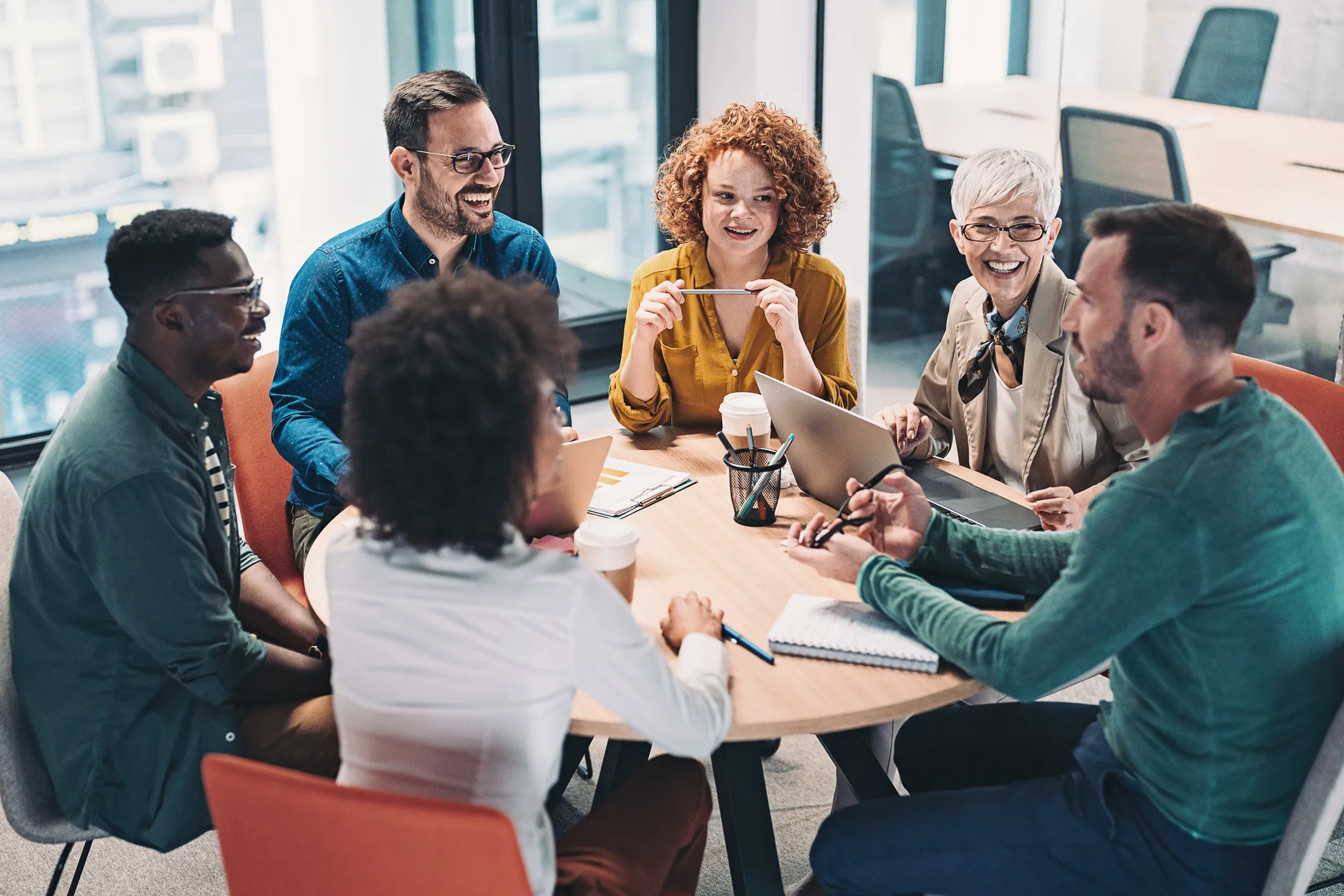 diverse group of business people sitting at a round table together