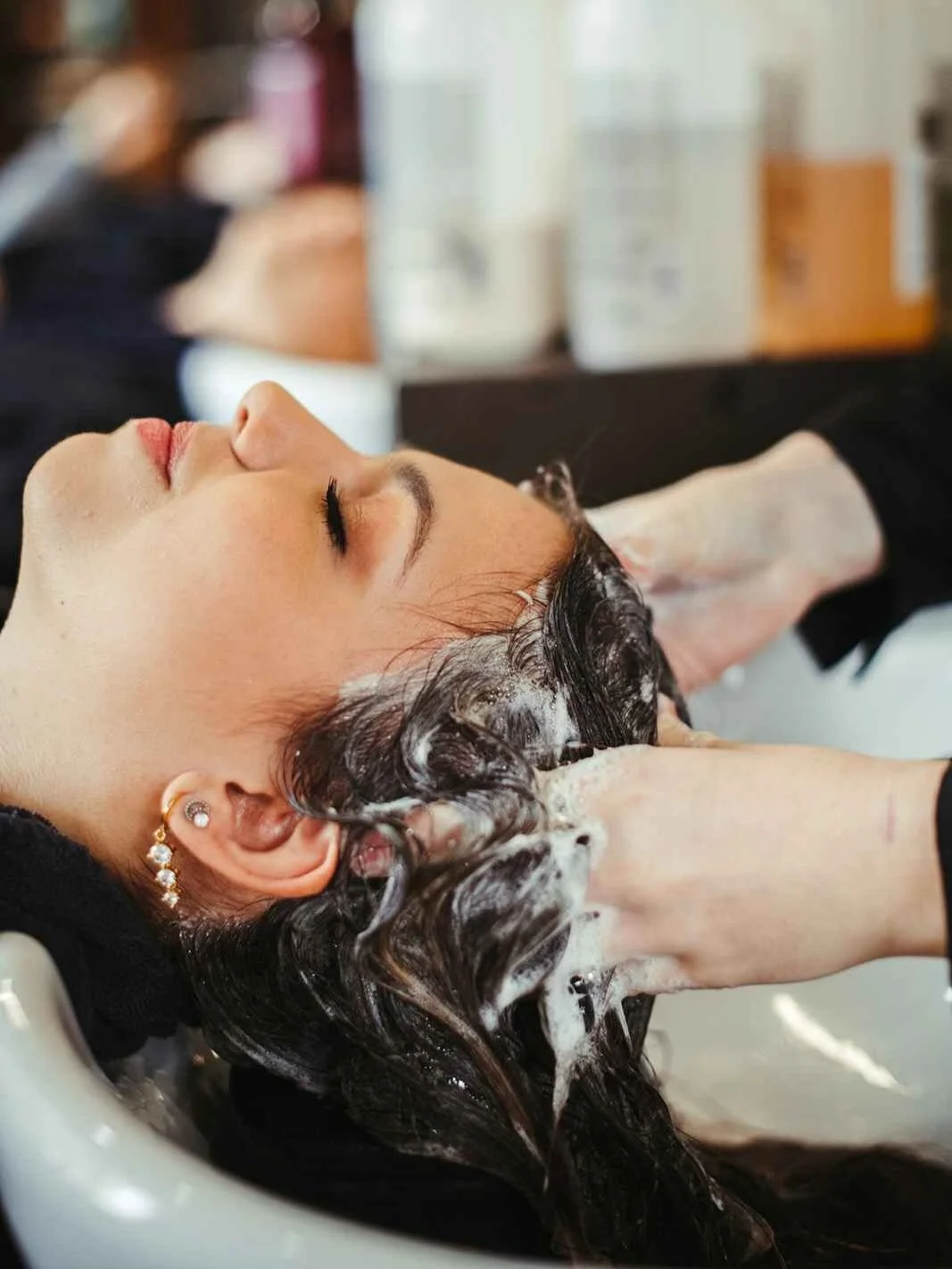 Applying hair treatment to woman's hair
