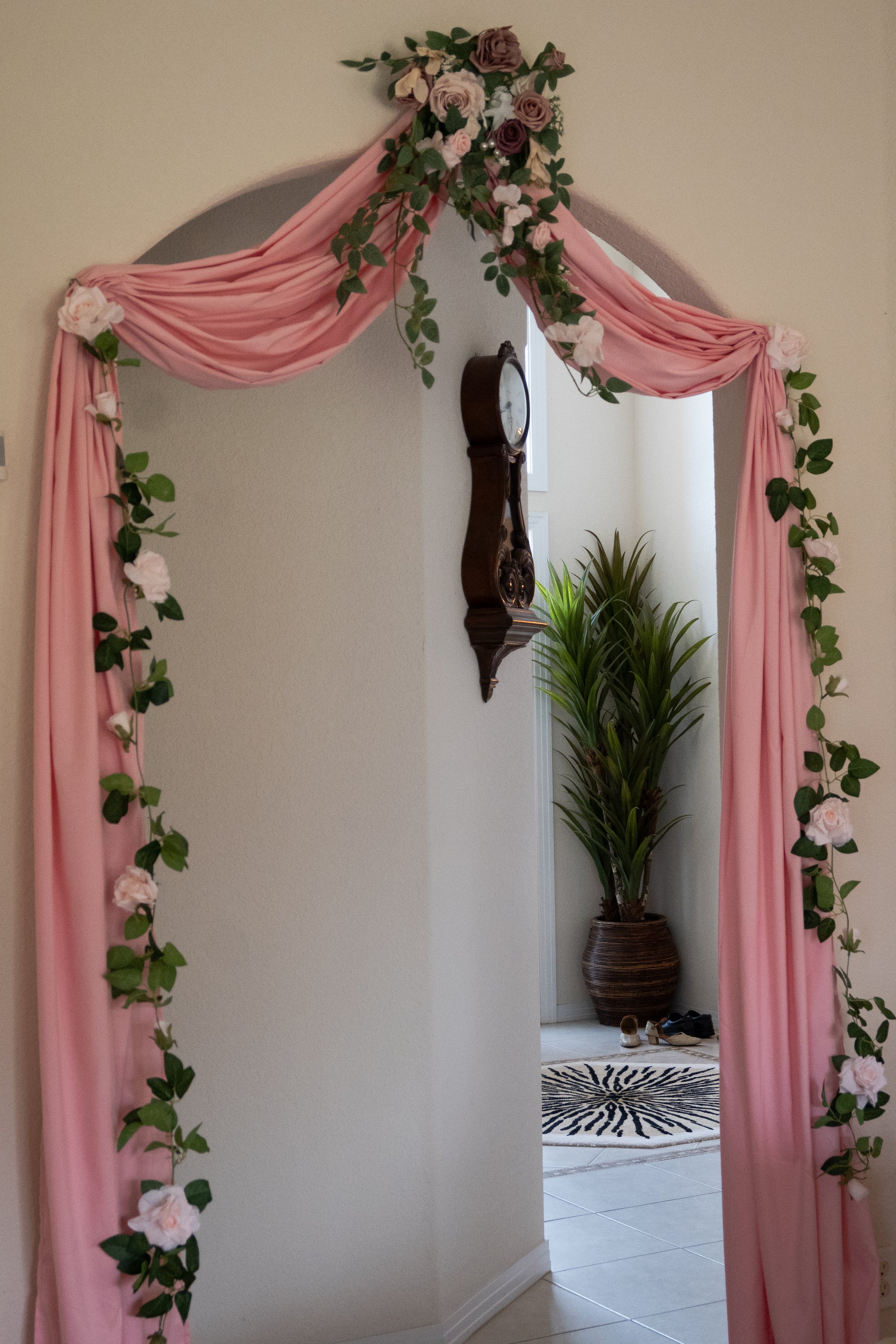 Photo of a walkway with a garland arrangement and a pink drape to celebrate a Traditional Indian Engagement Ceremony.