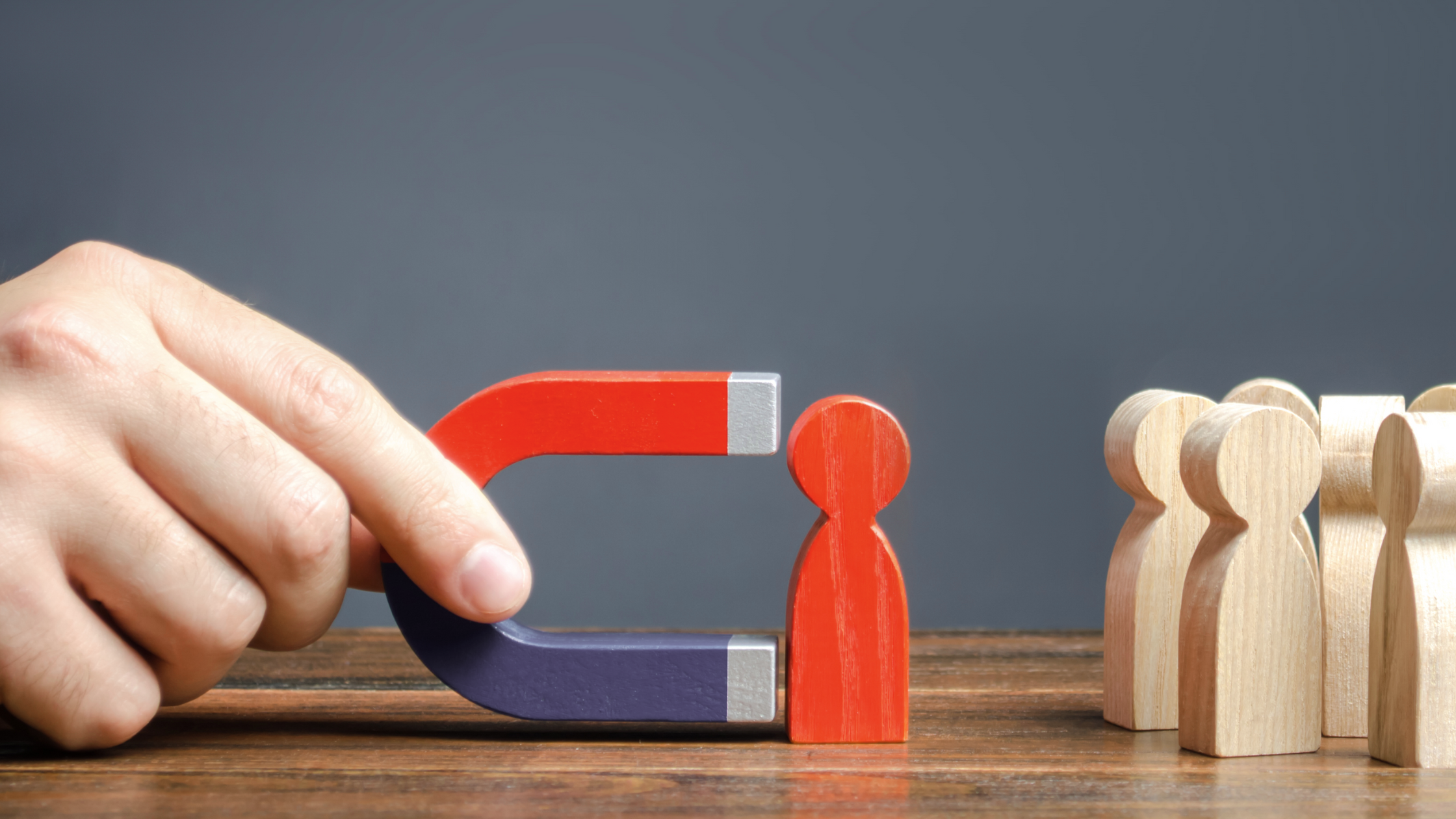 A hand is holding a magnet which has a figure attached to it