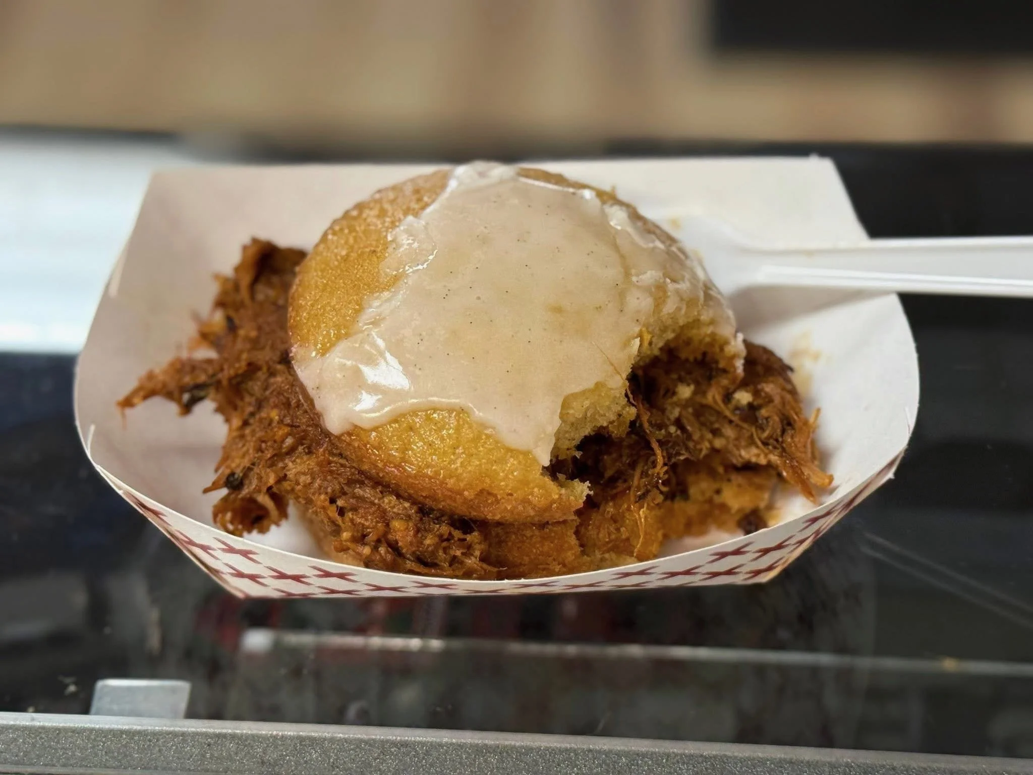 Funnel cake topped with vanilla ice cream and caramel sauce.