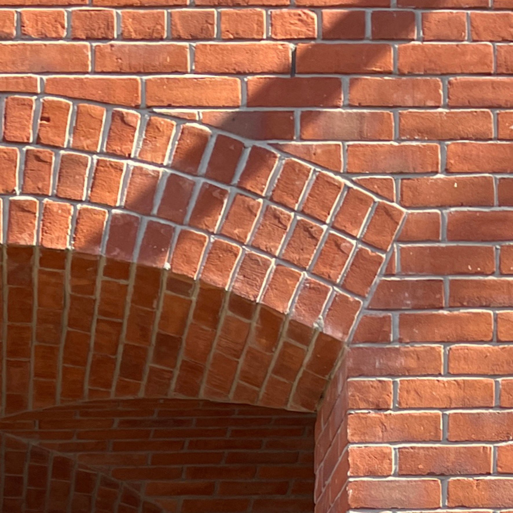 Close-up of a traditional brick arch detail, showcasing meticulous craftsmanship and the integration of heritage-inspired materials in a modern multi-unit residential project.